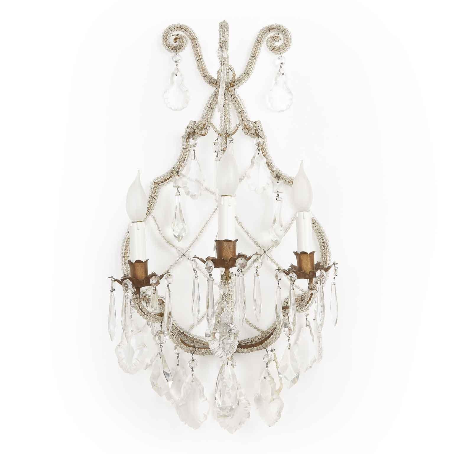 Charming pair of antique Italian beaded crystal sconces dating back to the late 19th century.
The square section brass frame, still showing gilding traces, is entirely covered with three rows of beads and embellished by an original woven net of