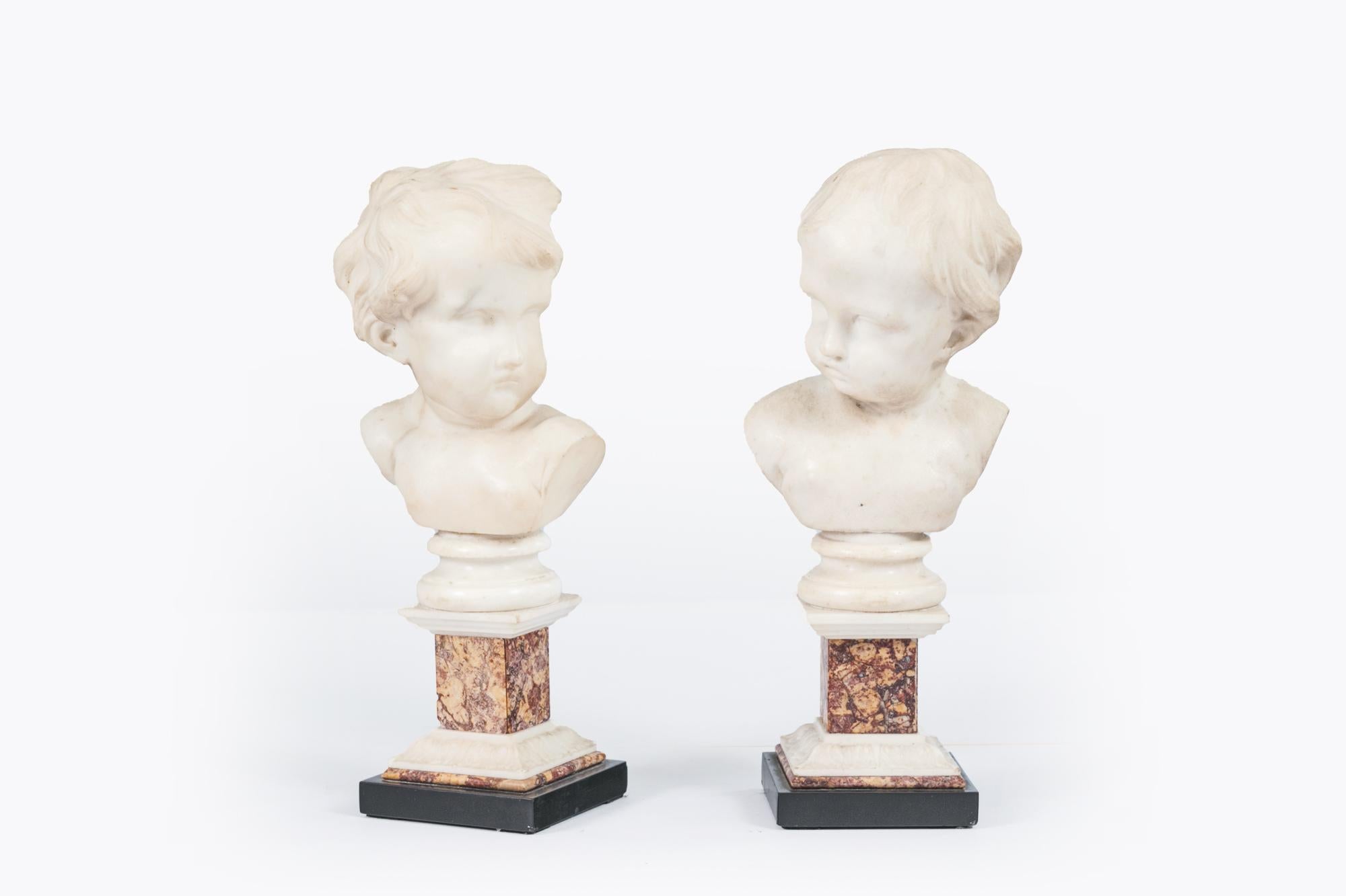 Pareja de bustos de mármol italiano del siglo XIX que representan a dos niños sostenidos sobre pedestales cuadrados de mármol Violeta Jura Brocatelle con detalles de mármol blanco y negro.