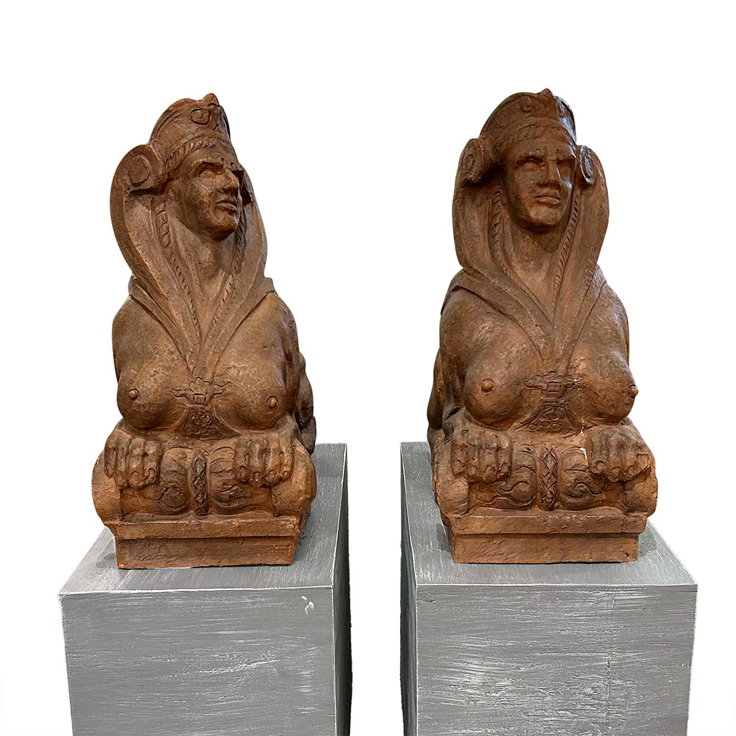 Antiguo par de estatuillas de esfinges italianas del siglo XIX, hechas a mano en terracota, en buen estado. Las detalladas estatuas del jardín toscano están colocadas sobre una base en forma de voluta, y se incluyen los zócalos de madera. La esfinge