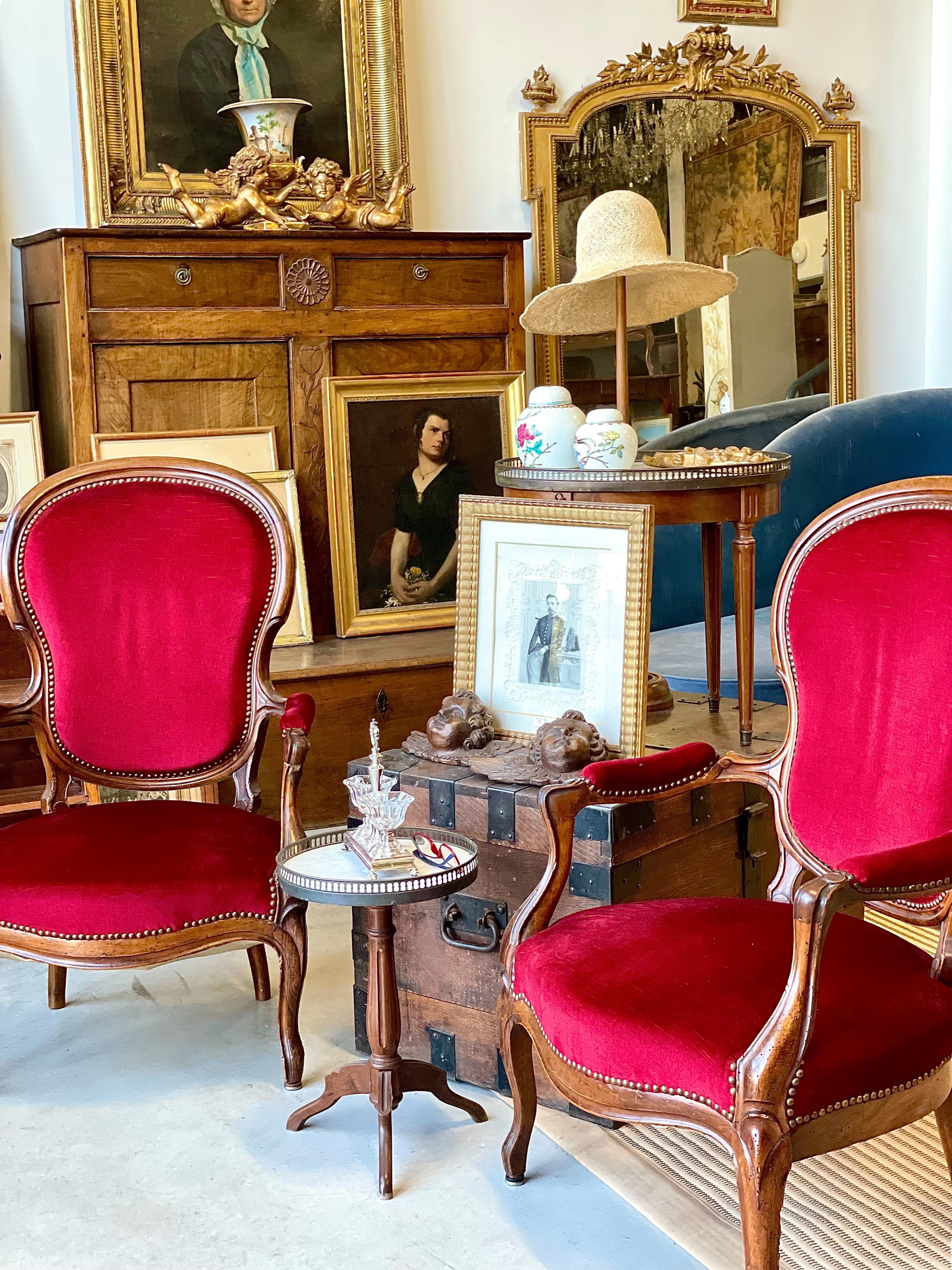 Questa raffinata coppia di poltrone del periodo Louis Philippe è realizzata in noce pregiato, esemplificando l'eleganza del design della metà del XIX secolo. Le sedie presentano linee graziosamente curve e intagli intricati, caratteristici della