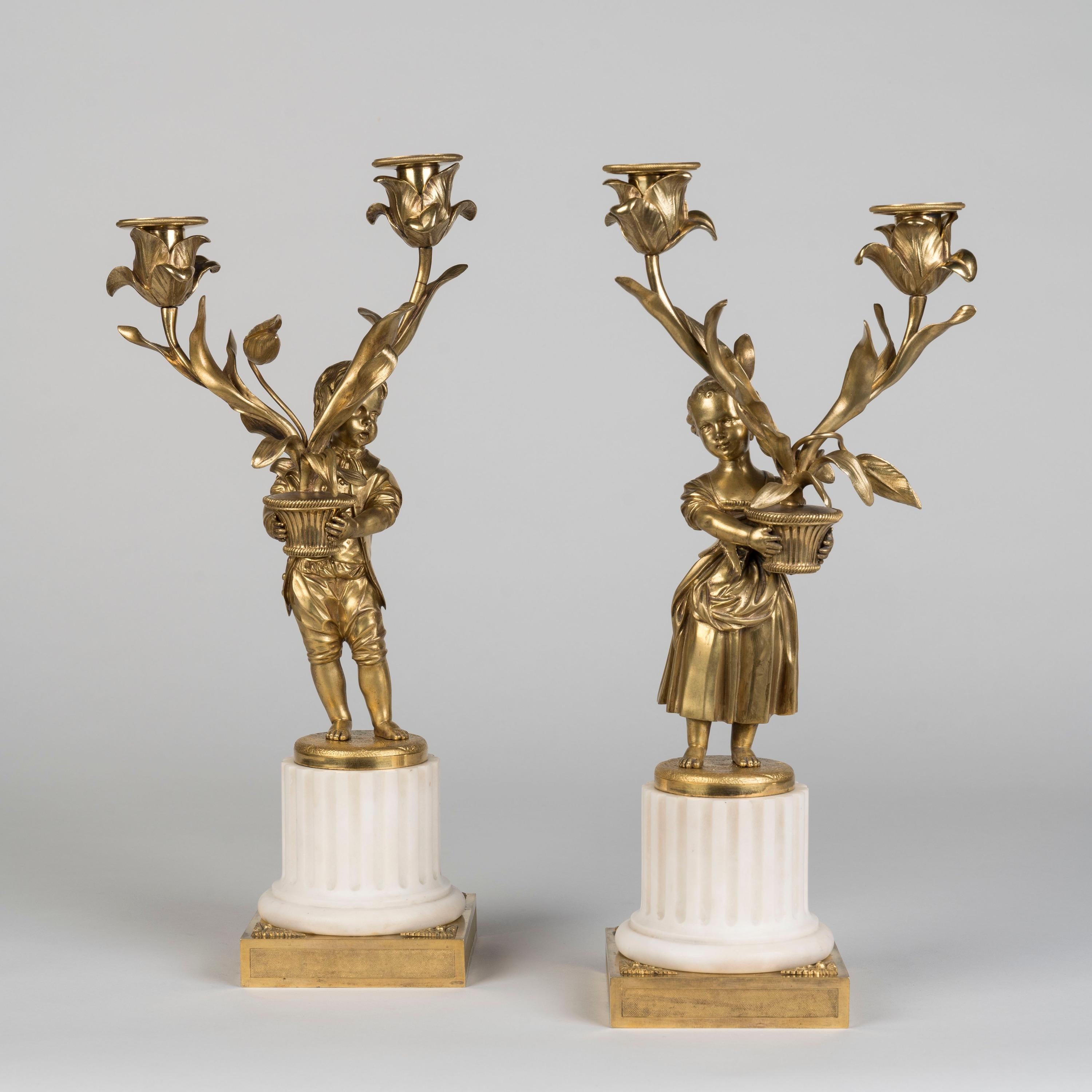 A Fine Pair of Figural Candelabra
Signed Eugène Hazart of Paris

Constructed in Carrara marble and finely cast gilt bronze, rising from a square gilt panelled base, each candelabrum with a fluted column surmounted by a figure of a child, holding a