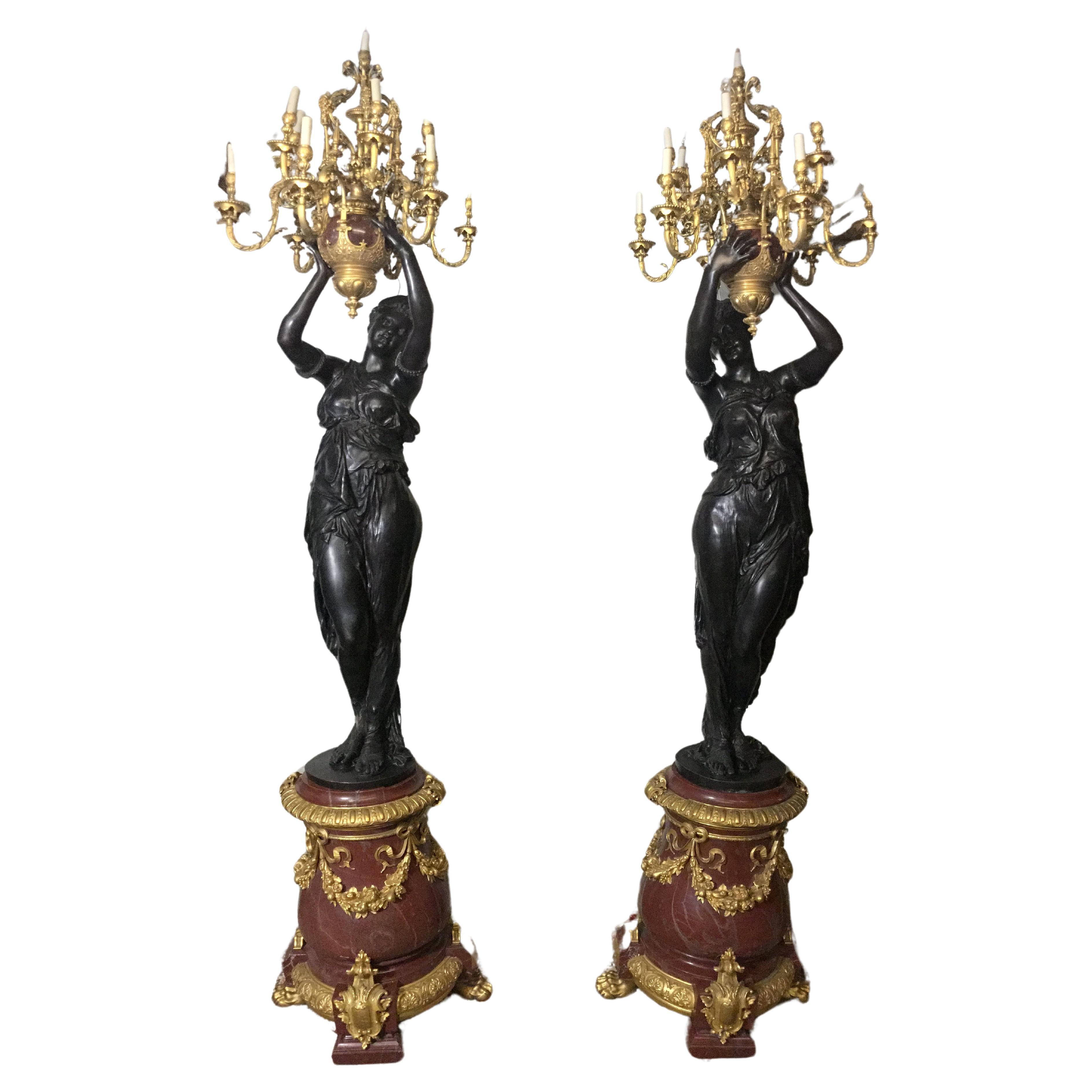 Paar figurative Fackeln aus patinierter Bronze mit Marmorsockel aus dem 19. Jahrhundert