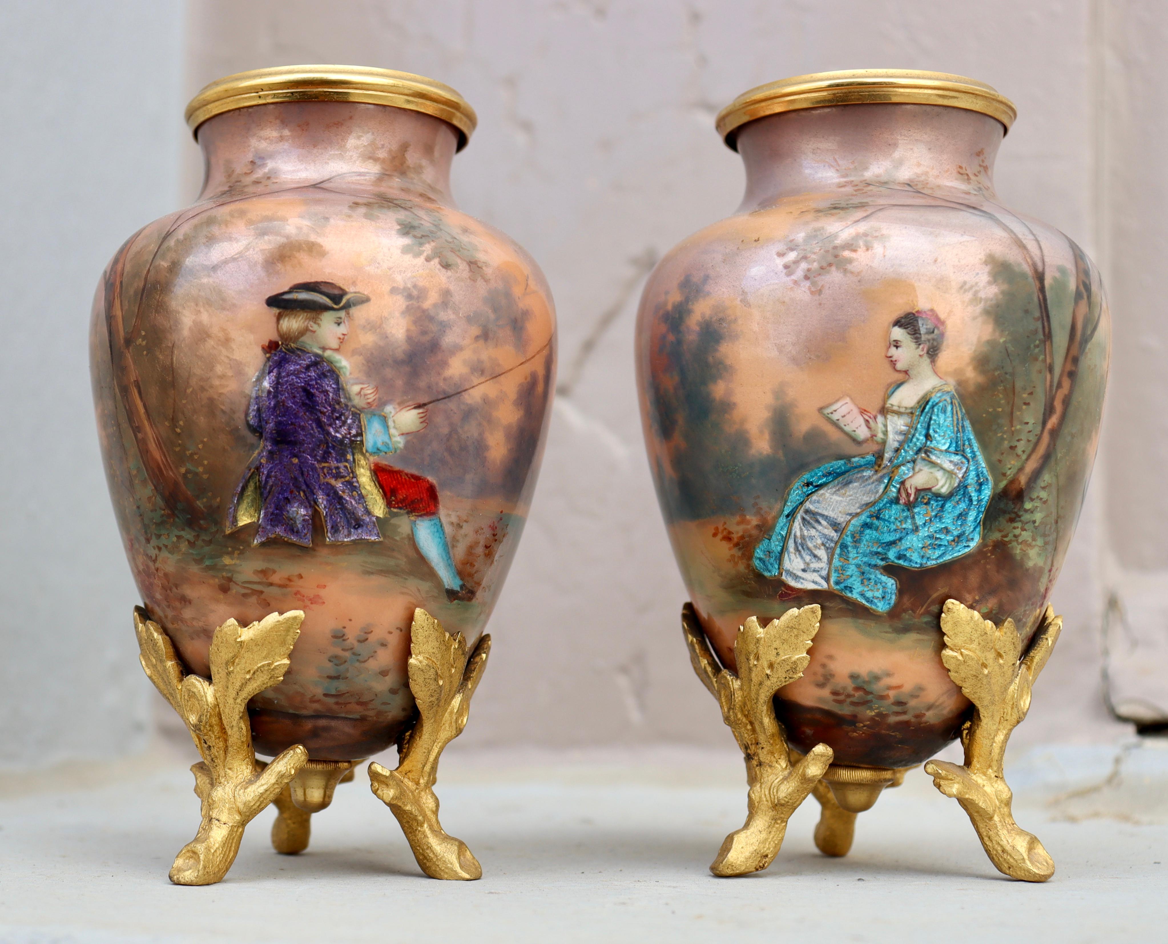 A 19th century pair of Limoges enamel on copper miniatures vases
Hand-painted polychromed enamel design of pastoral scene showing a couple of romantic lovers
Resting on three ormolu feet simulating leaves and branches
With original flowers