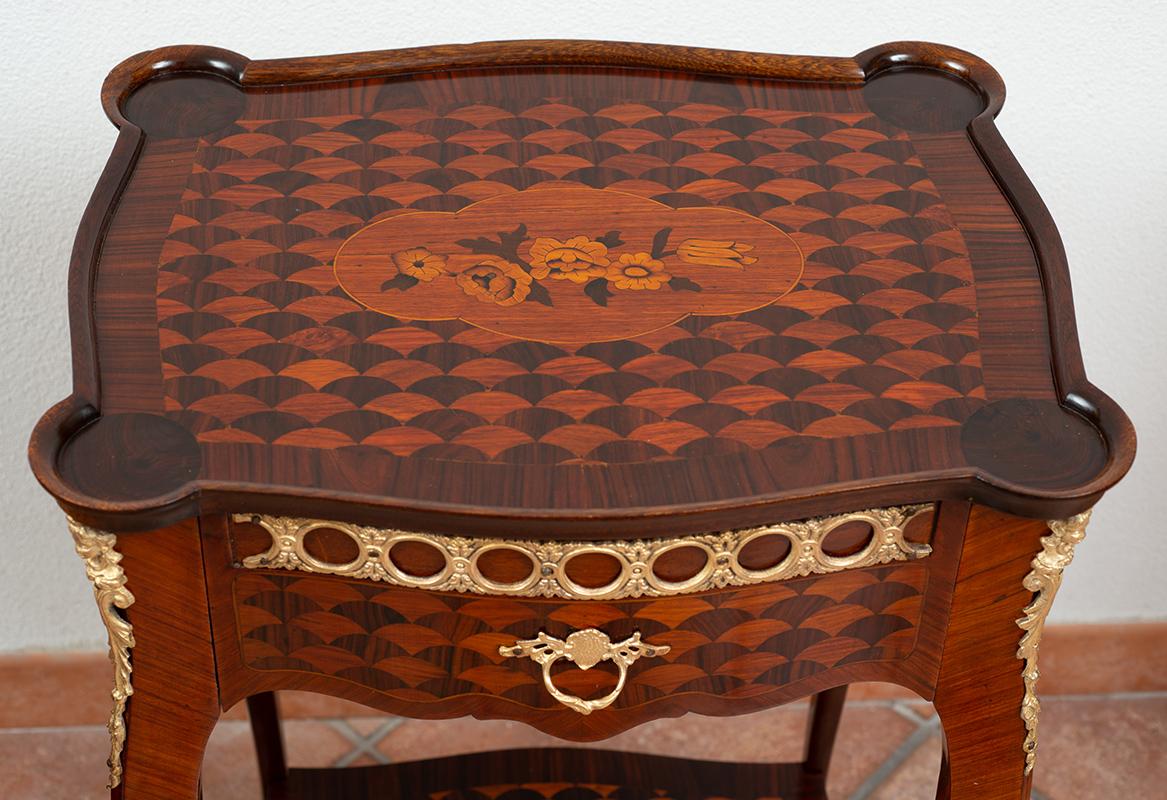 Elegant and ancient pair of French bedside tables, Napoleon III, made with exotic wood and adorned with finely chiseled and gilded bronze applications. The bedside tables have a front drawer, and a shelf that connects the four curved feet with final