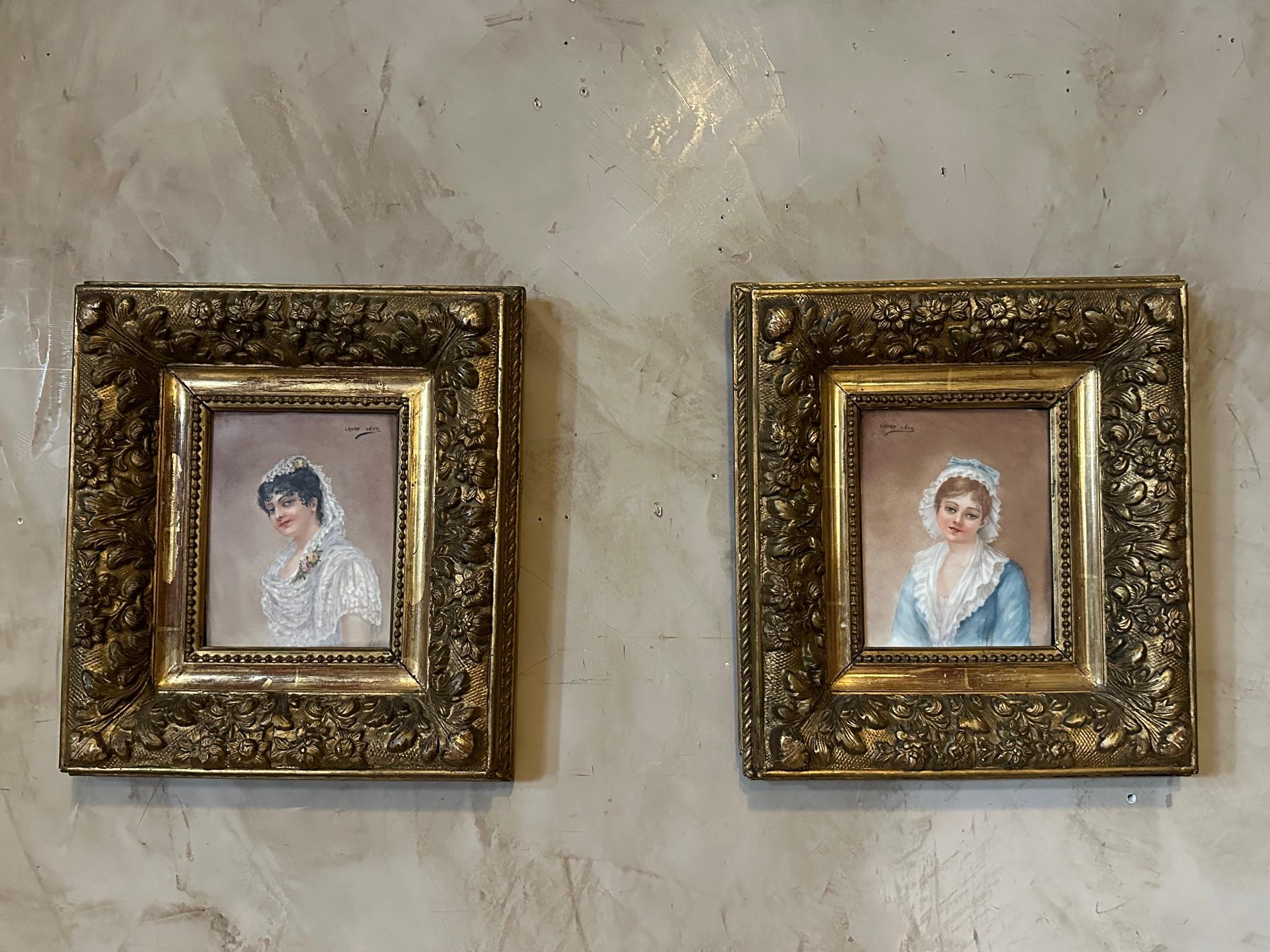Paire de portraits à l'huile sur porcelaine datant du XIXe siècle signés par Laure Lévy représentant deux jeunes femmes. 
Magnifique cadre en bois doré.
Laure LEVY est une artiste née en France en 1866 et décédée en 1954.