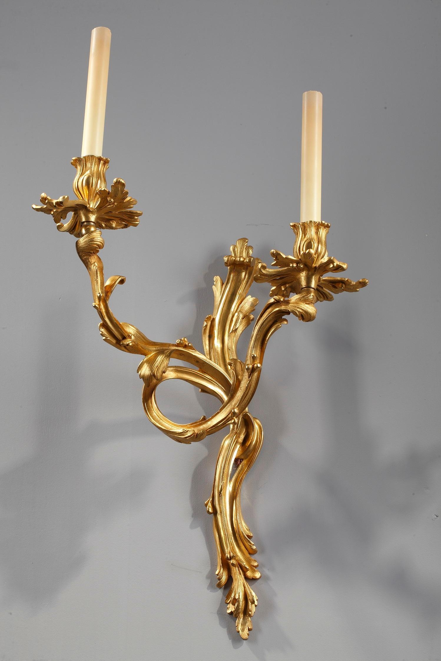 Napoleon III large pair of chiseled and gilt bronze two-light antique wall sconces sculpted with flowing foliage and scrolls in Louis XV style. This Rococo decor is dominated by asymmetrical forms, beautiful carving and the taste for