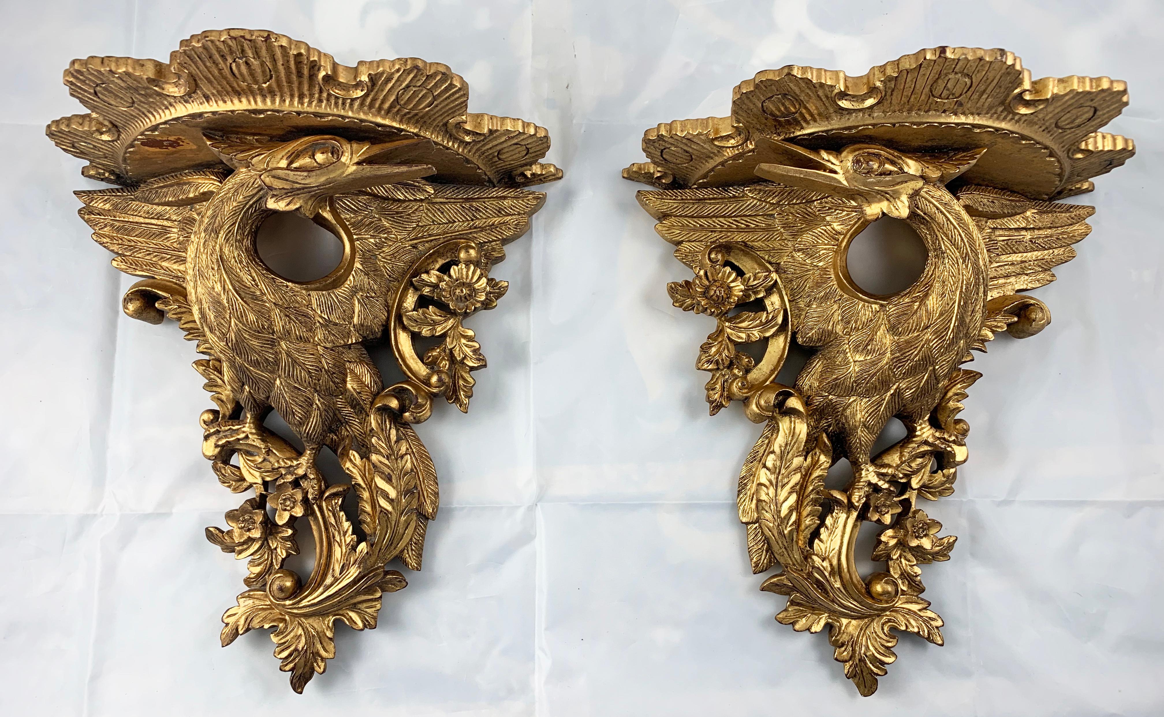 An ornate pair of carved gilt wood wall brackets. Made in France in the 19th century. Each one features a hand carved pair of Phoenix birds facing each other.