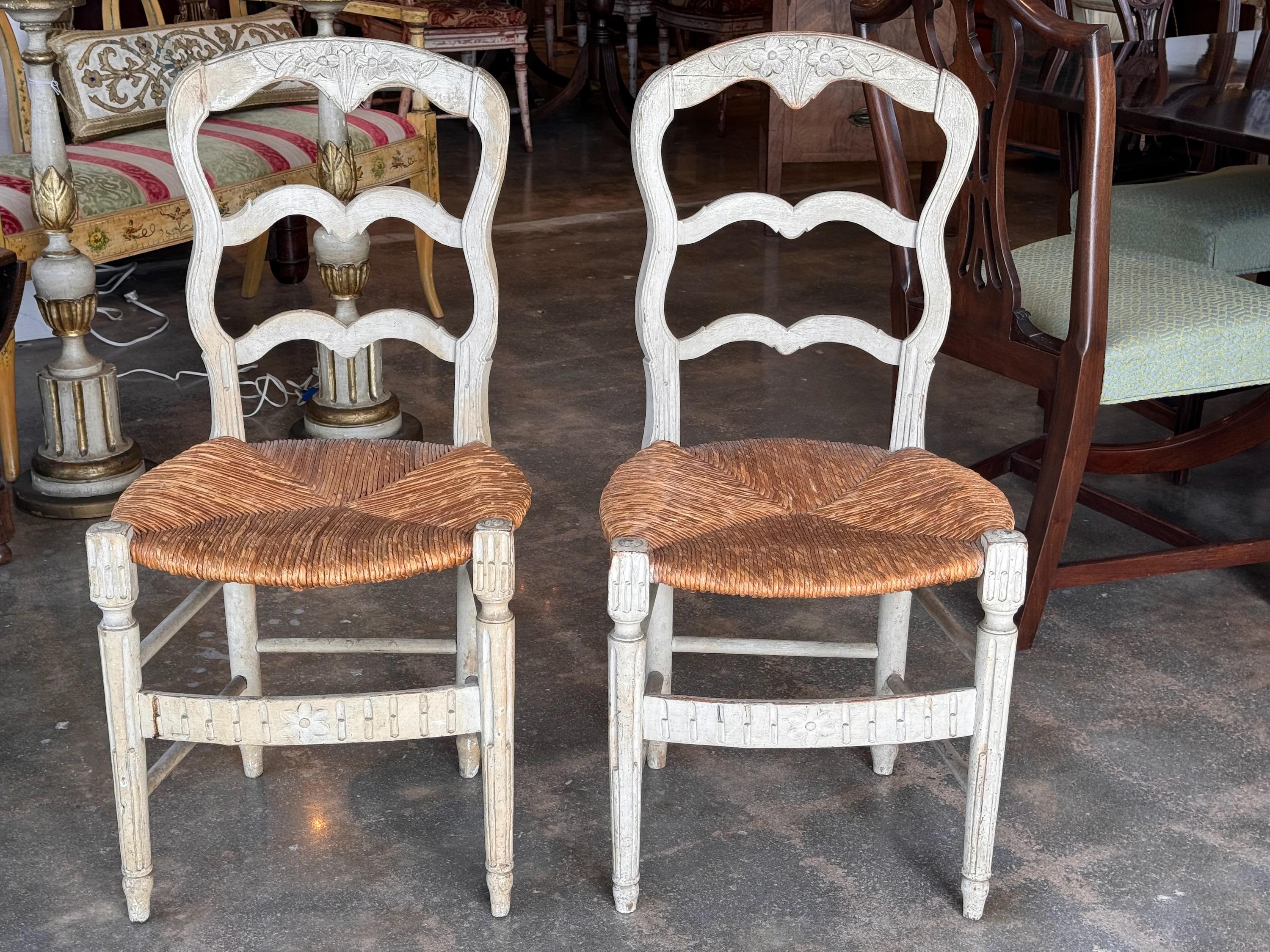 Country chic . A pair of French side chairs, with charming paint.
