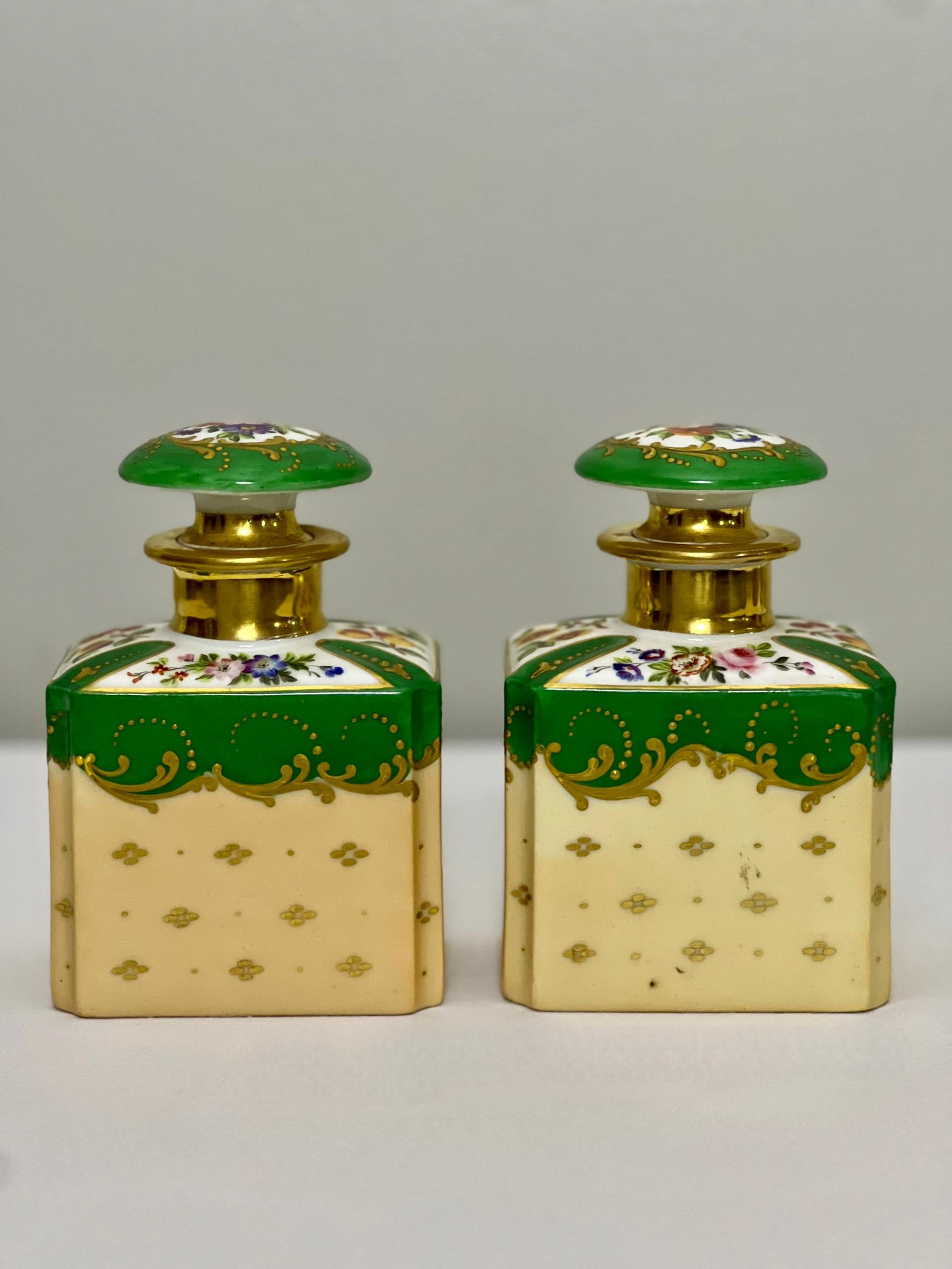 Striking pair of 19th century Old Paris Porcelain dresser/vanity toiletry bottles with stoppered tops, France, circa 1840.  These bottles were opulent vessels used to store perfumed water, oil, powders and creams.  Beautifully shaped and bursting