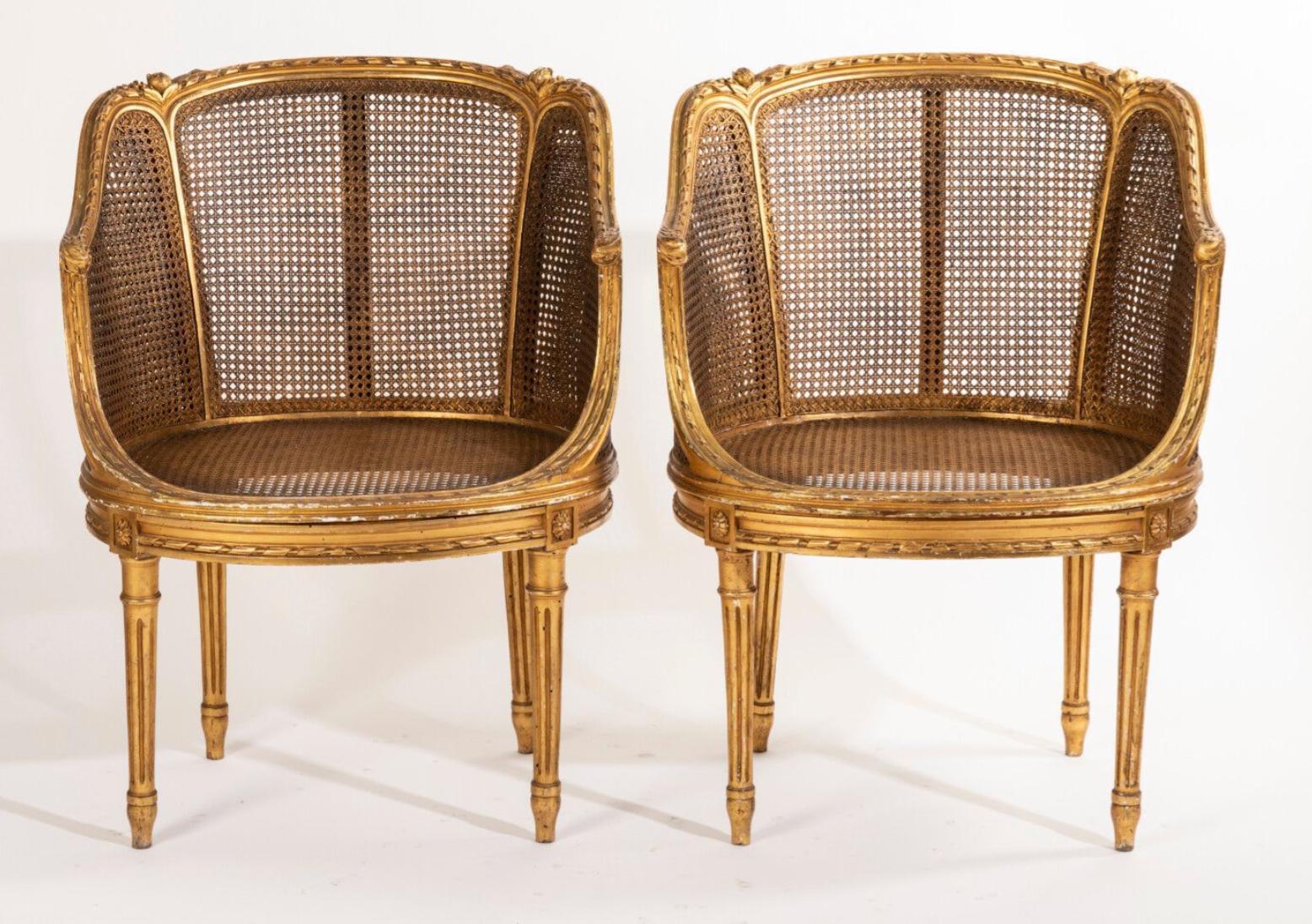 Petite French ballroom round chairs, in Louis XVI style hand carved and gilded frames decorated with friezes of ribbons and roses, tapered fluted base, both with cane backs and the seats. Very good condition.
France, circa 1870.
 