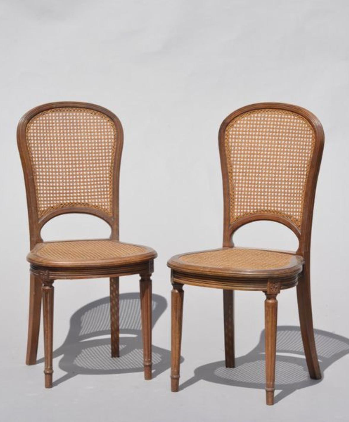 Paar zierliche französische ovale Beistellstühle im Louis XVI-Stil aus Nussbaum mit unterschiedlichen Vorderbeinen mit Kanneluren. Handgeschnitzter Rahmen, Rückenlehnen und Sitze mit Rohrgeflecht,
um 1890.