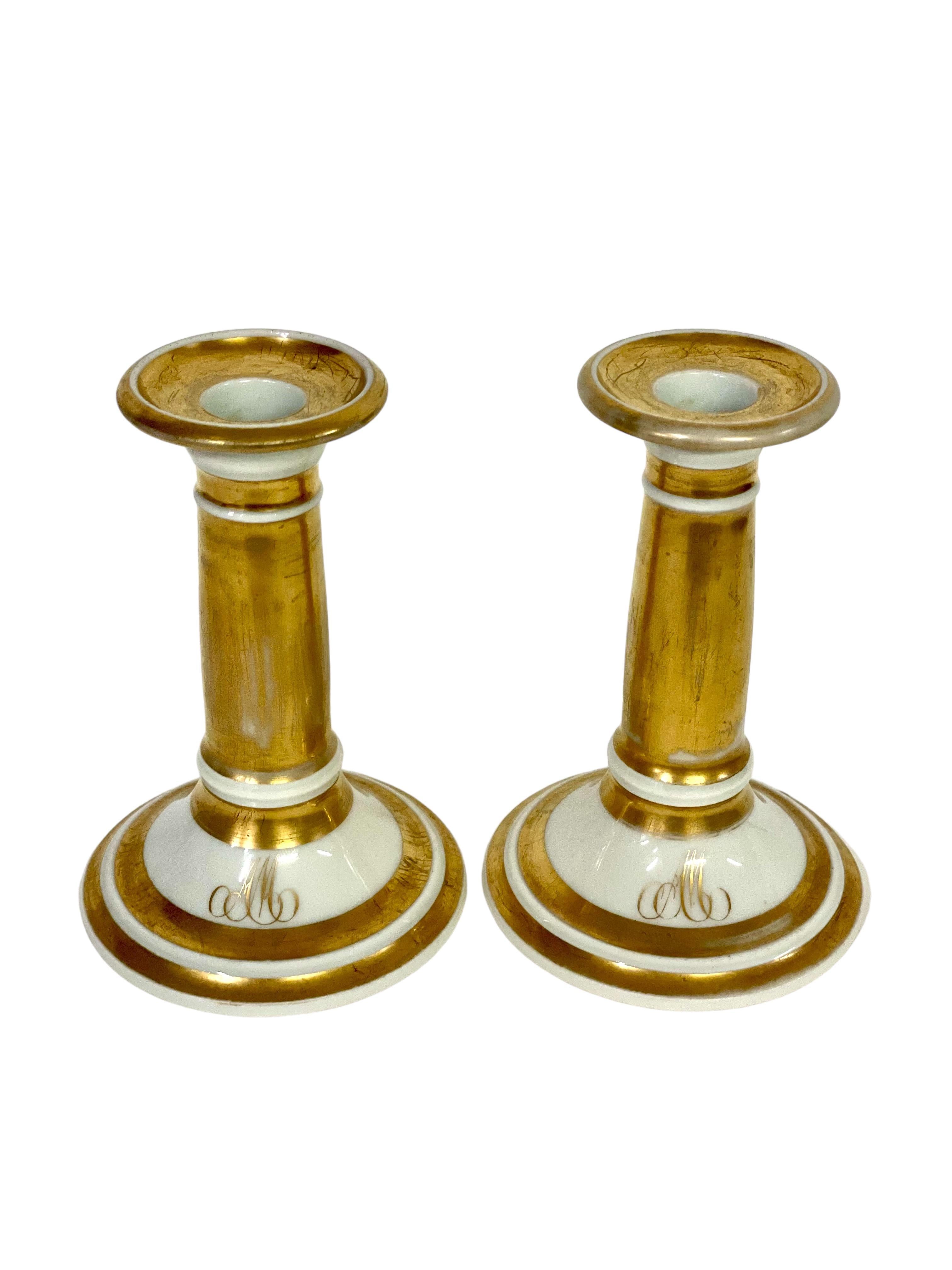 Una bella coppia di piccoli candelieri in porcellana, monogrammati con le iniziali 