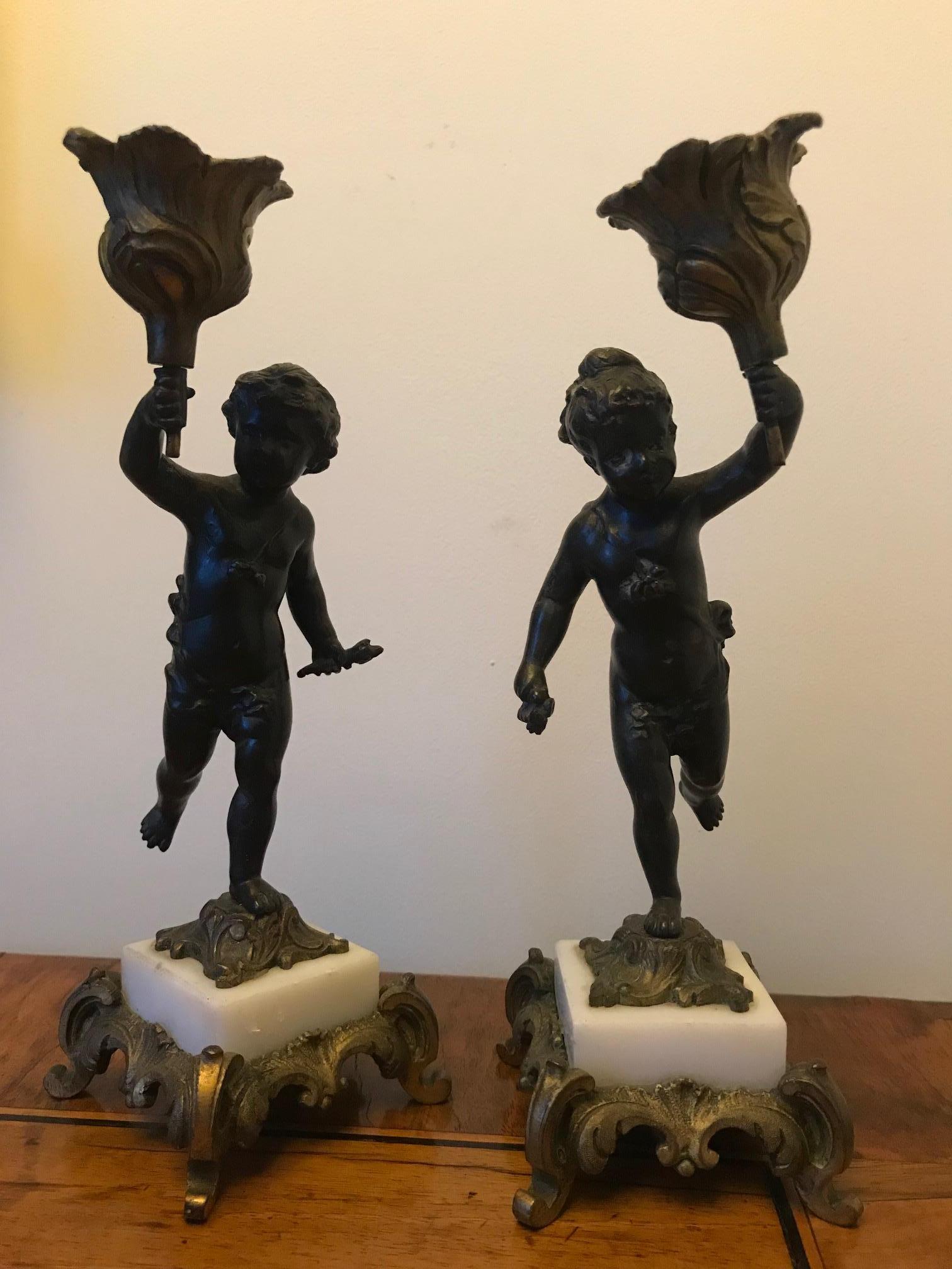 A very attractive pair of French 19th century small bronze and ormolu cherub candlesticks mounted on white marble bases.