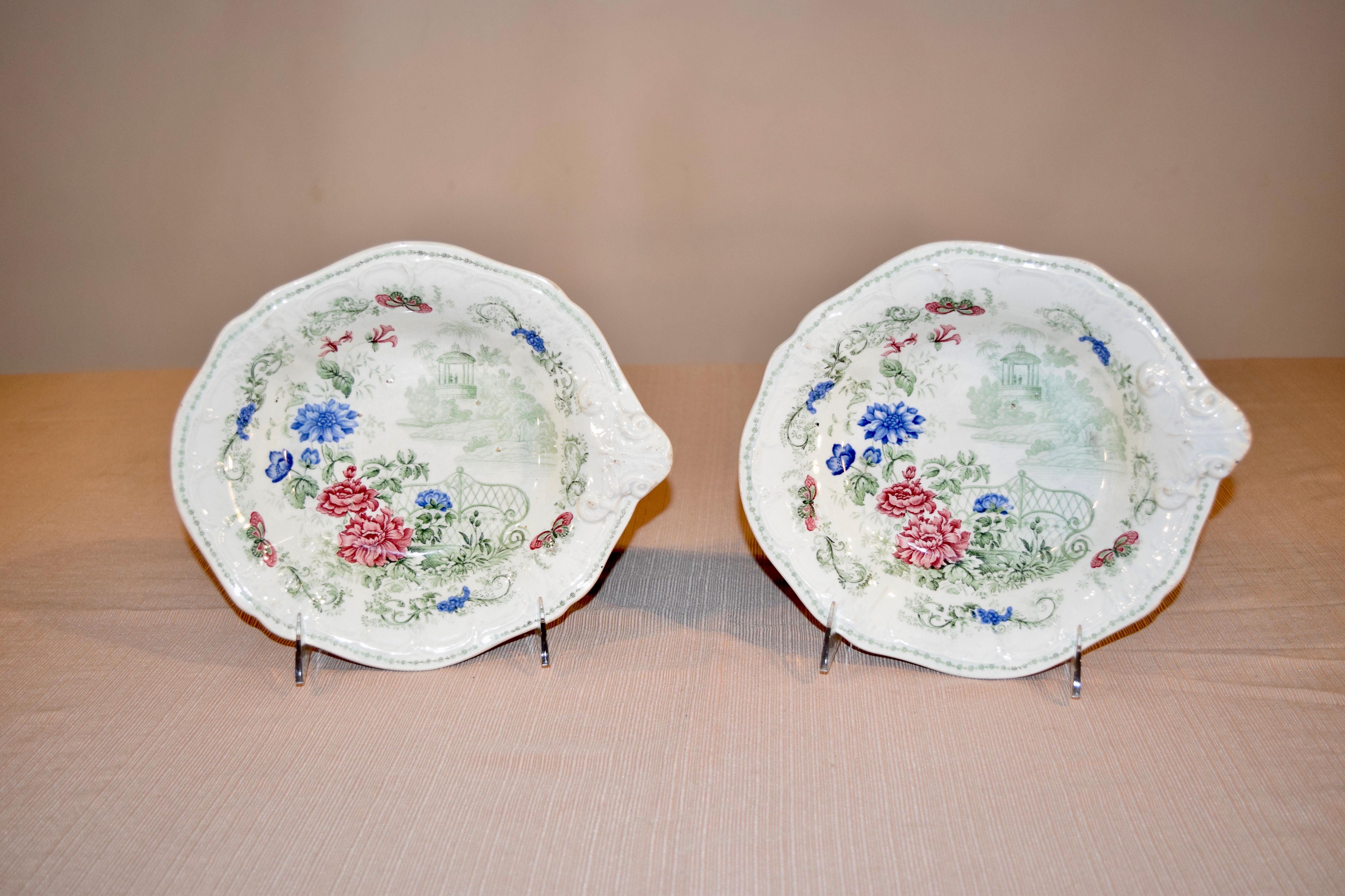 Pareja de platos del siglo XIX con decoración en transfer multicolor que representa un jardín con flores y mariposas de colores vibrantes. Vajilla de piedra con la marca 