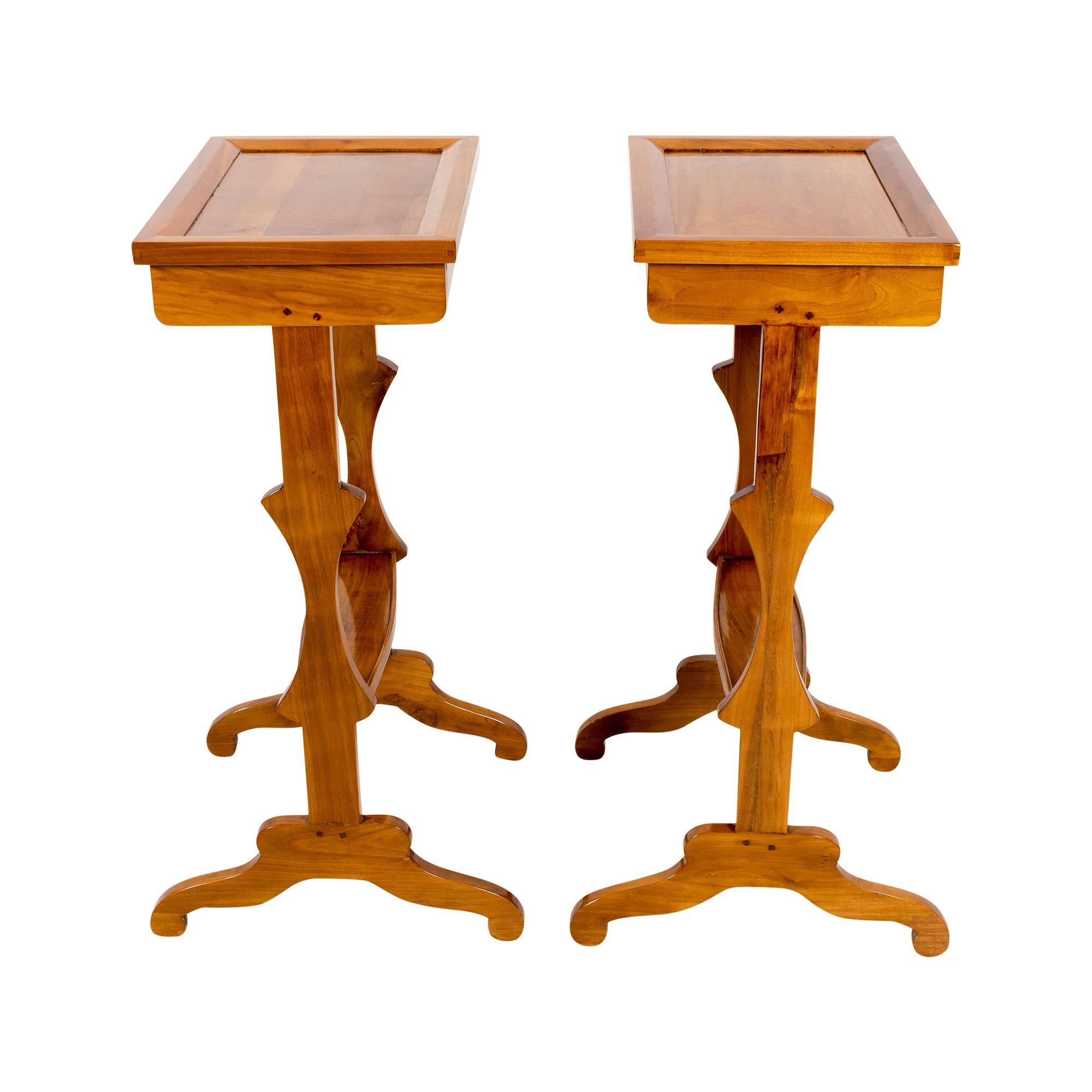 Very nice filigree pair of side tables made of solid cherrywood from France from the time around 1850. Both tables have a drawer with a brass button to open. The tables are in very good restored condition.
