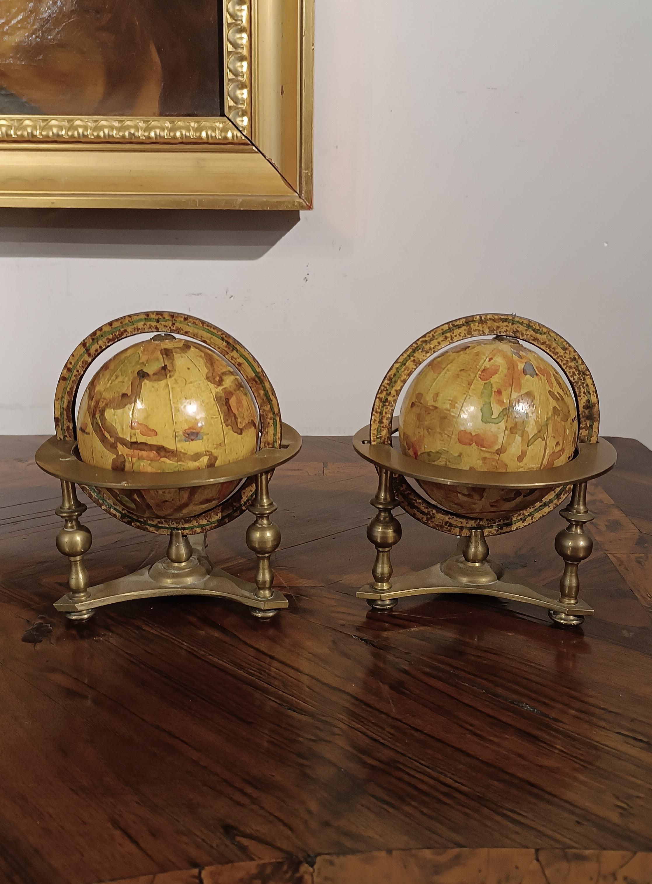 Unique and fascinating pair of small globes, made with artisanal care by Italian manufacturers in the 19th century and hand painted on fine paper. These small globes are mounted on a solid brass base, equipped with three legs and a pedestal, making