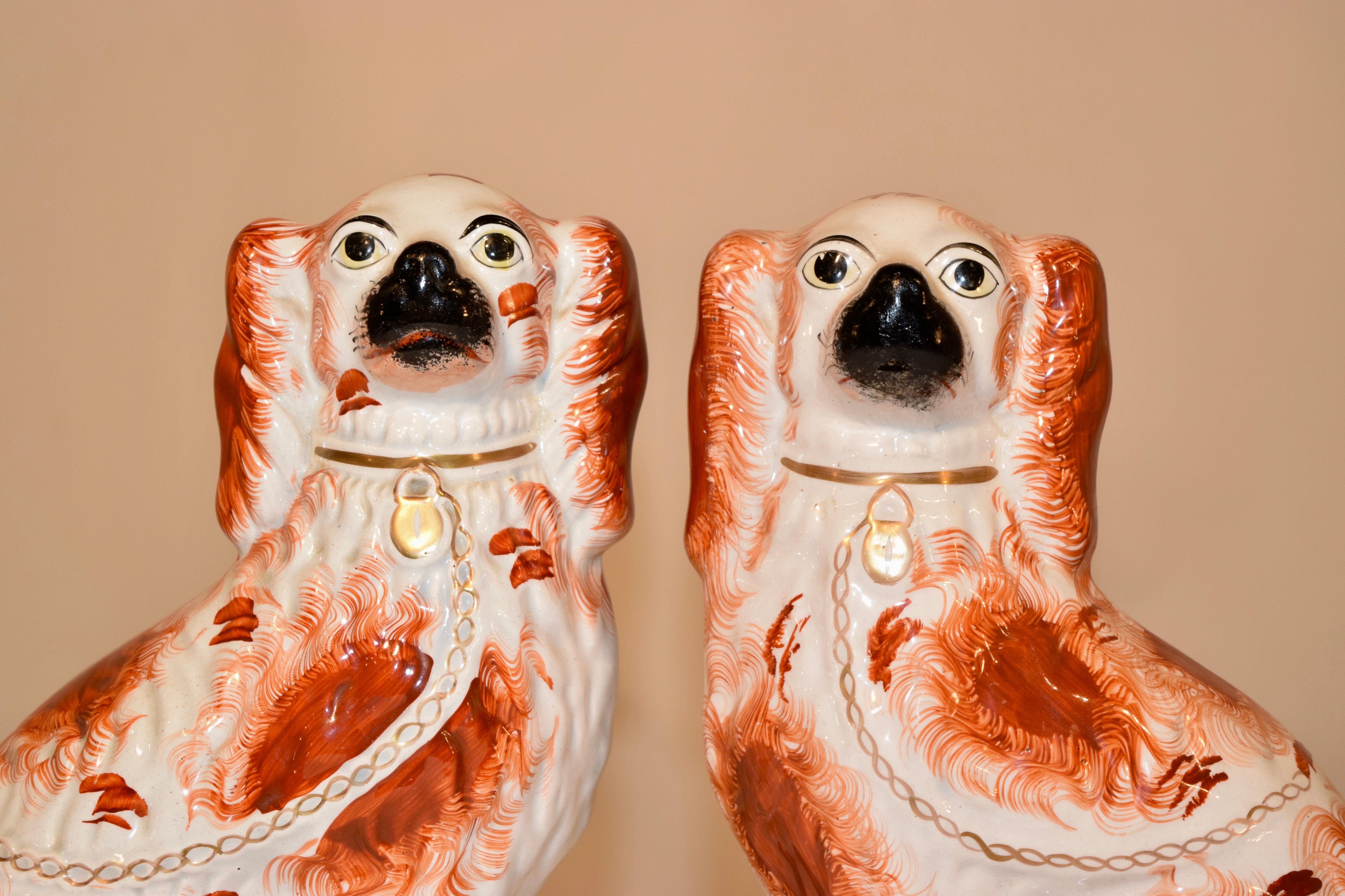 19th century pair of Victorian Staffordshire spaniels in rust and white from England. They have black muzzles and wonderfully expressive faces.