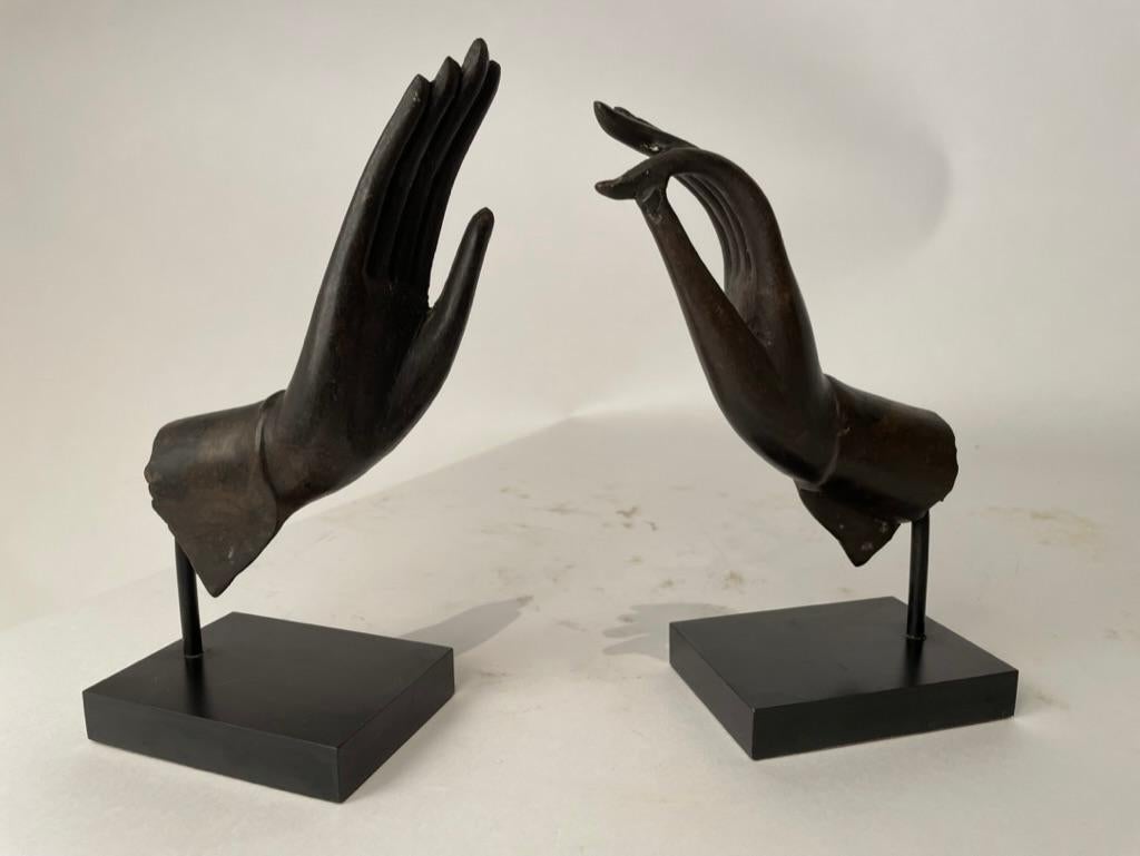 Elegant pair of bronze hands of the Buddha displaying two ritual gestures, the Abhaya mudra, which represents protection, peace, benevolence, and the dispelling of fear from the mind, replacing it with inner peace. And the Vitarka mudra, symbolizing