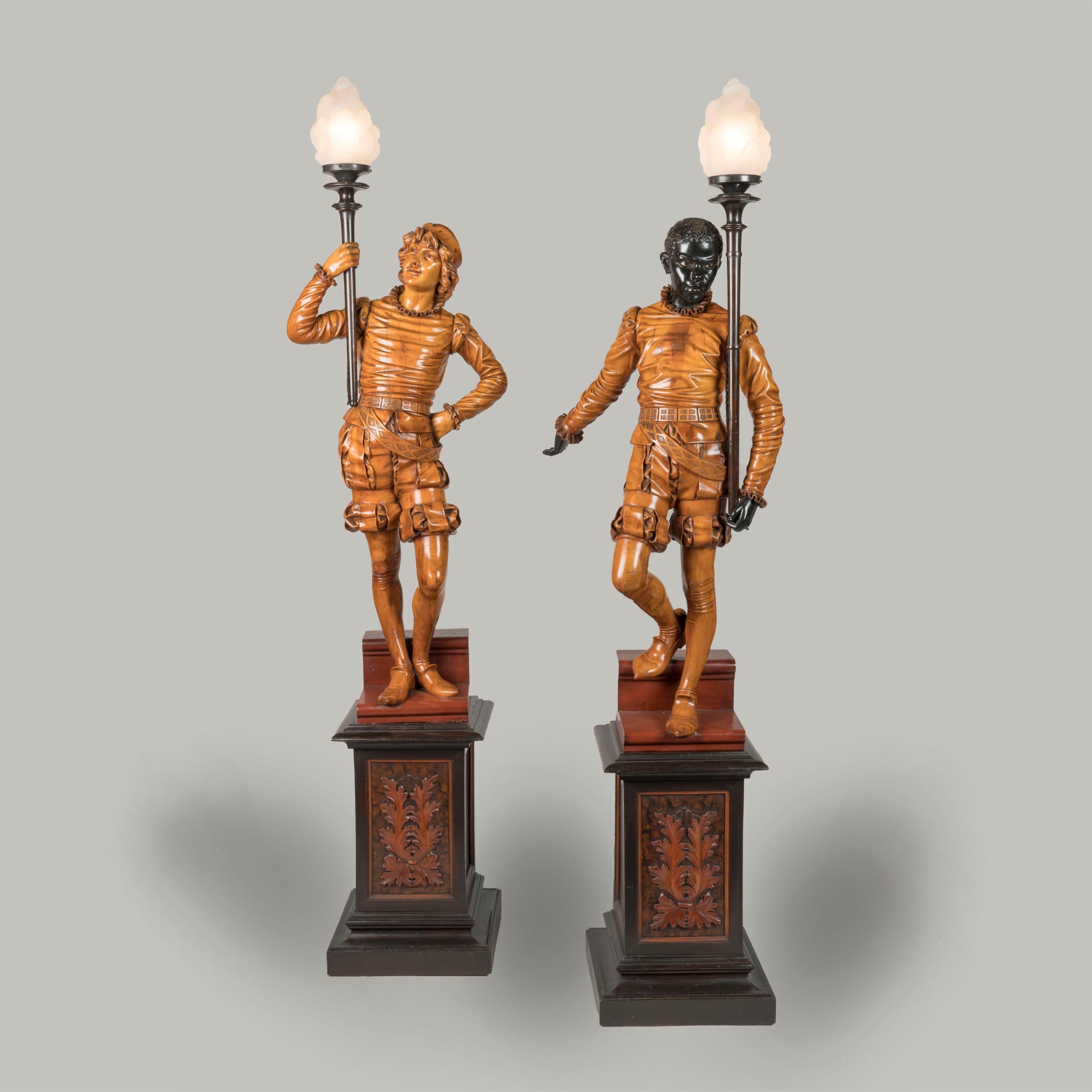 A Splendid Pair of Venetian Figural Torchères
Attributed to Valentino Panciera Besarel

Of solid carved pine, waxed, blackened and beeswax-polished throughout. Each figure carved with virtuosic realism, wearing identical Renaissance style garb