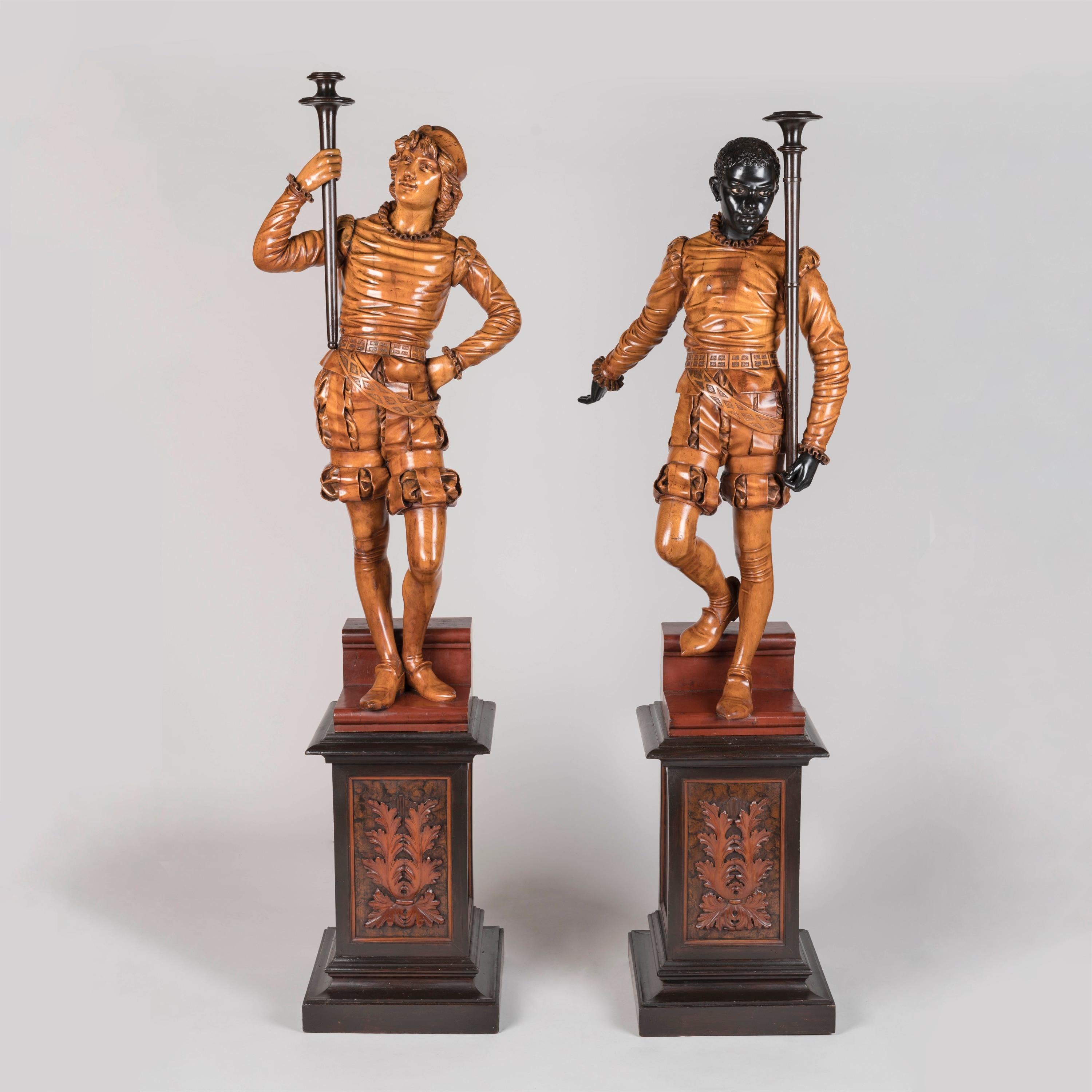 A Splendid Pair of Venetian Figural Torchères
Attributed to Valentino Panciera Besarel

Of solid carved pine, waxed, blackened and beeswax-polished throughout. Each figure carved with virtuosic realism, wearing identical Renaissance style garb
