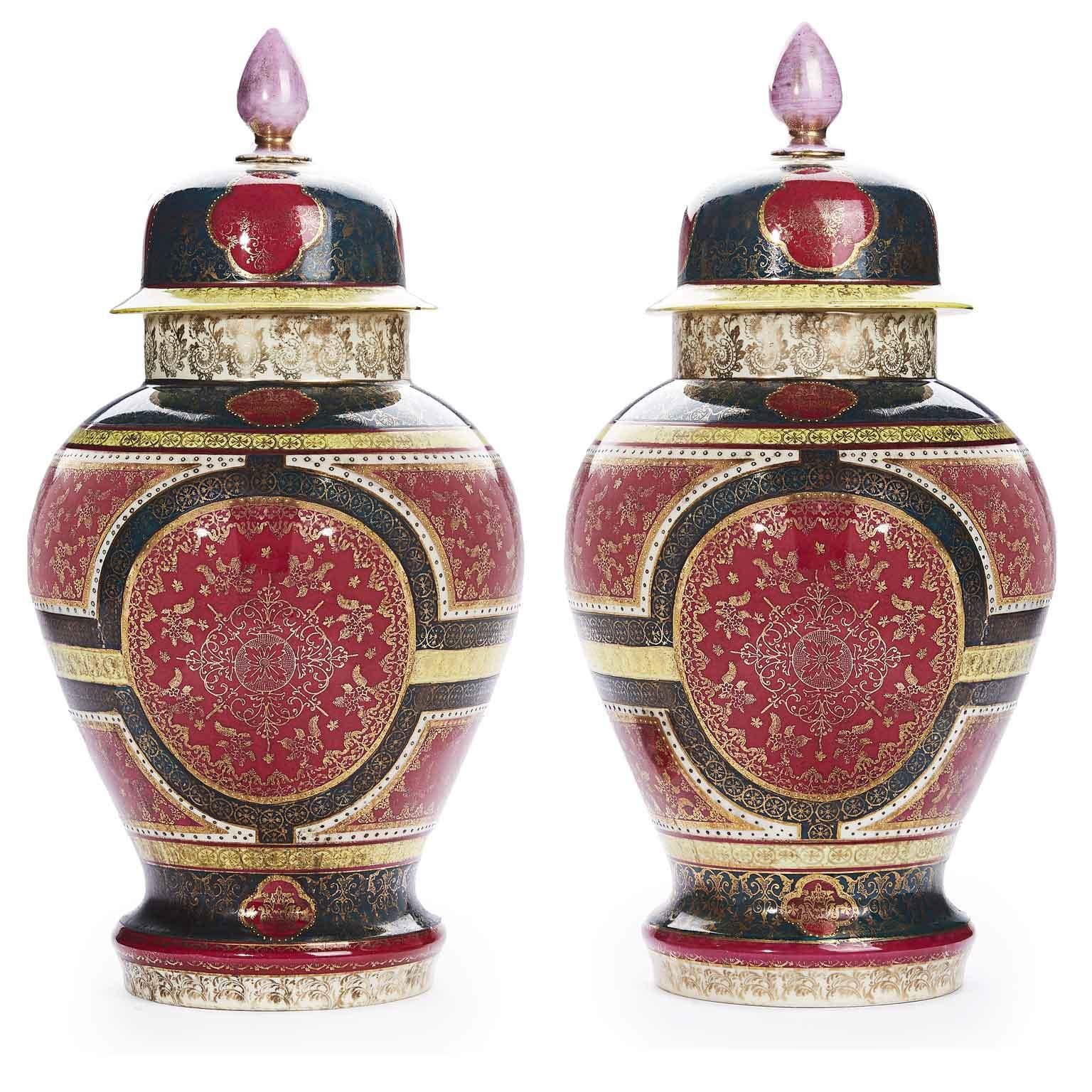 Pair of 19th century Royal Vienna porcelain vases, antique Austrian pair of potiche vases decorated in red, green and yellow colors, with removable lid. The deep red ground is richly throughout decorated with gilded details, with gilt arabesque,