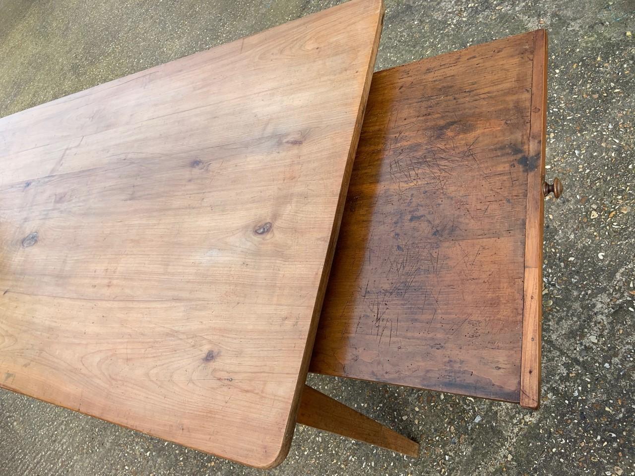 19th century pale rustic cherry wide farmhouse dining table. 19th century pale wide cherry dining table with bread slide. Table sits on apron with beautiful tapered legs. Lovely wide pale top.
