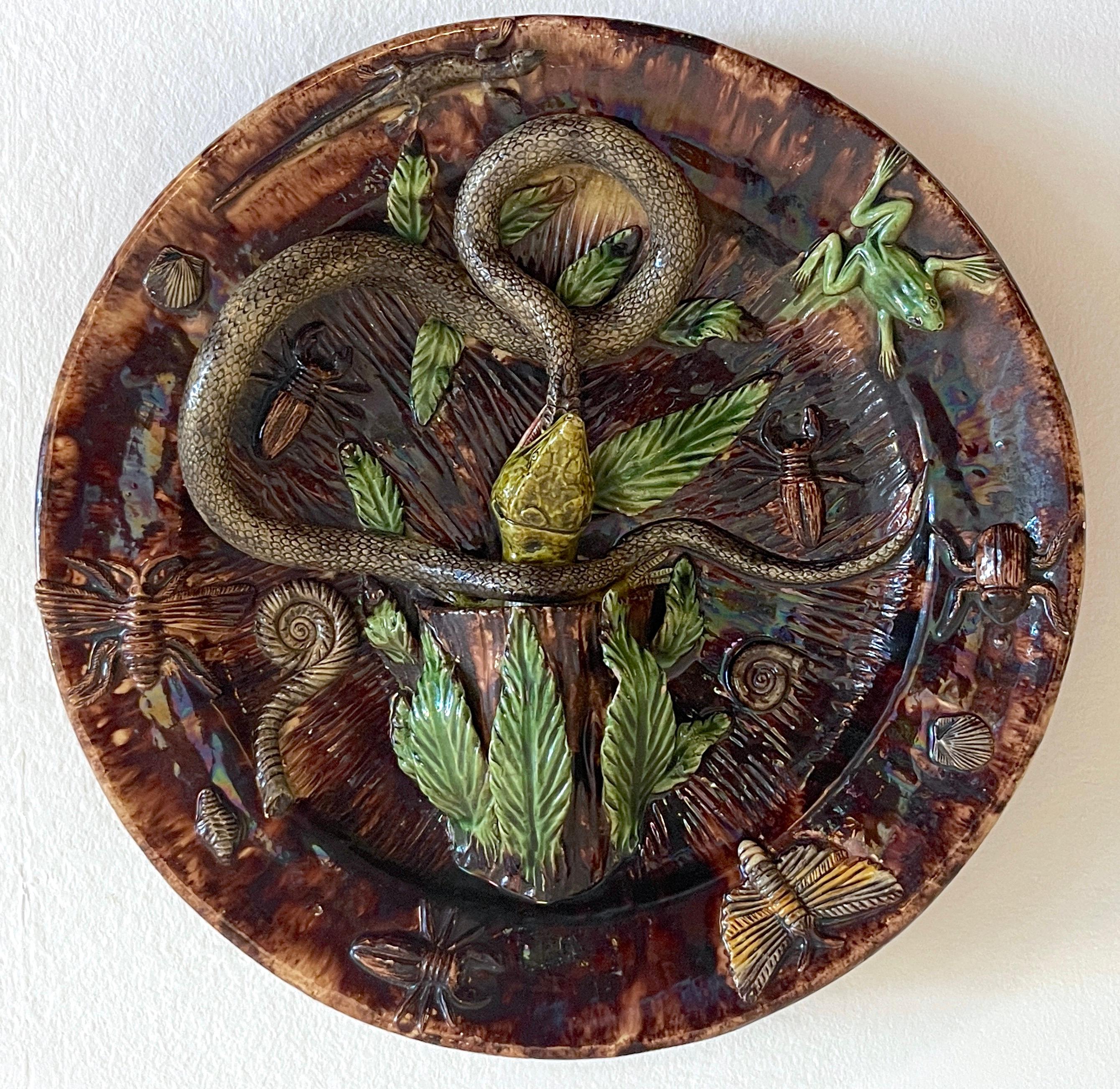 19th Century Palissy Majolica snake & lizard charger
A extraordinary large example, The center with a lizard grasping the serpents head in a naturalistic background, modeled in realistic three-dimensional glazed pottery, the perimeter applied with