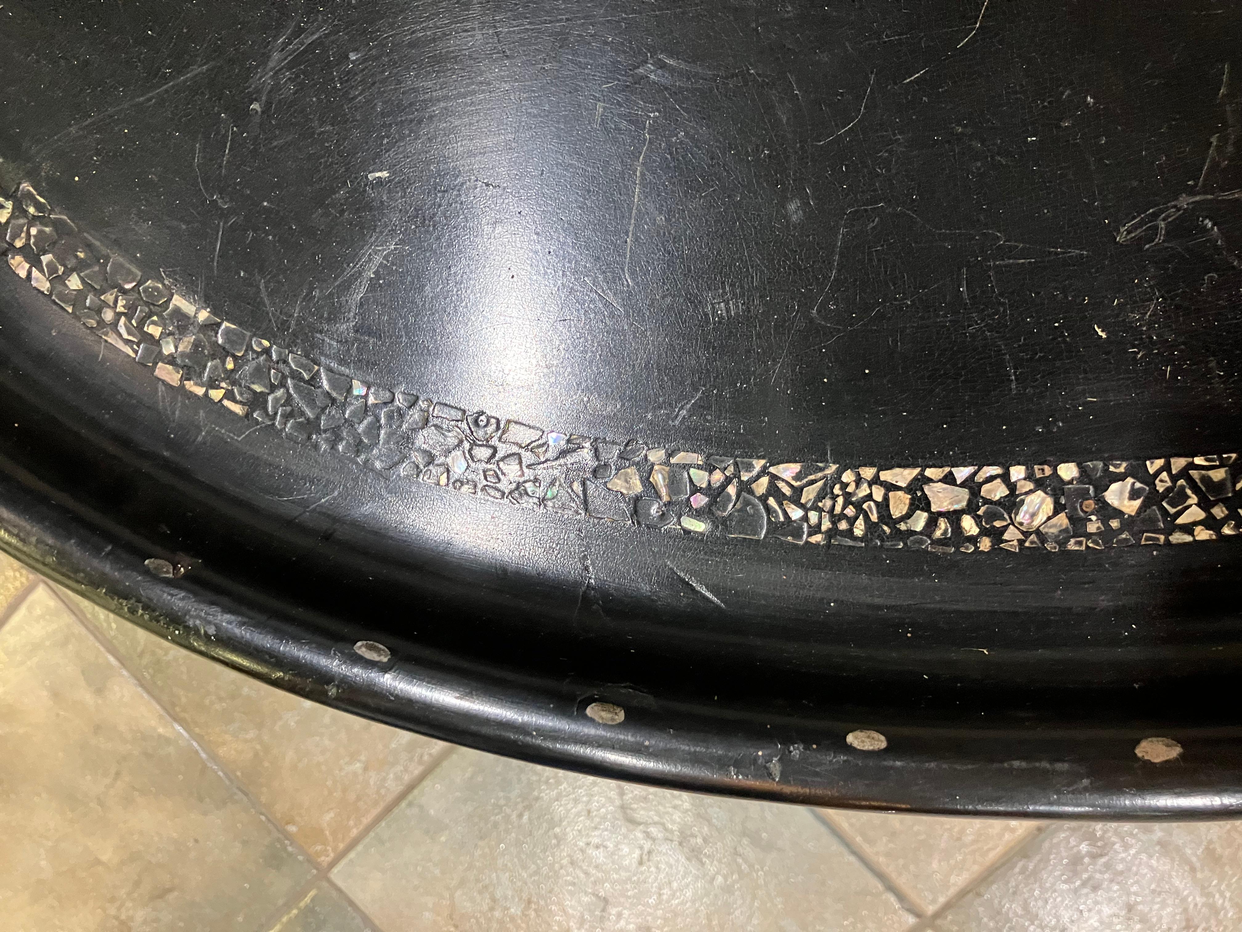 Two-piece coffee table composed of a detachable top and base, dating to the 19th century. The tabletop is crafted in papier-mâché, featuring hand-inlaid mother-of-pearl and a pattern of hand-embossed dots. The base is designed in a faux bamboo