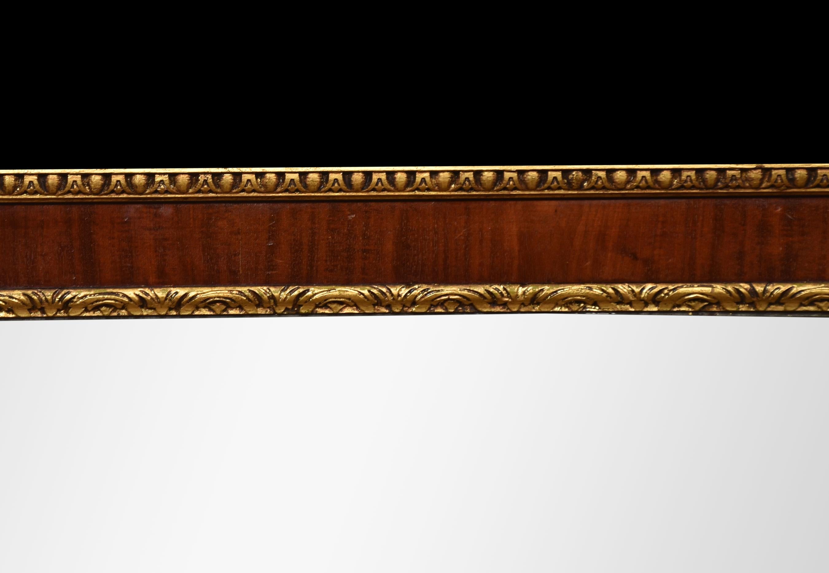 Miroir rectangulaire à trois plaques en acajou doré du XIXe siècle. Le cadre est bordé d'une moulure en forme d'œuf et de fléchette, les plaques de miroir sont encadrées de bordures de feuillage stylisé, chaque angle est orné d'une fleur, les côtés