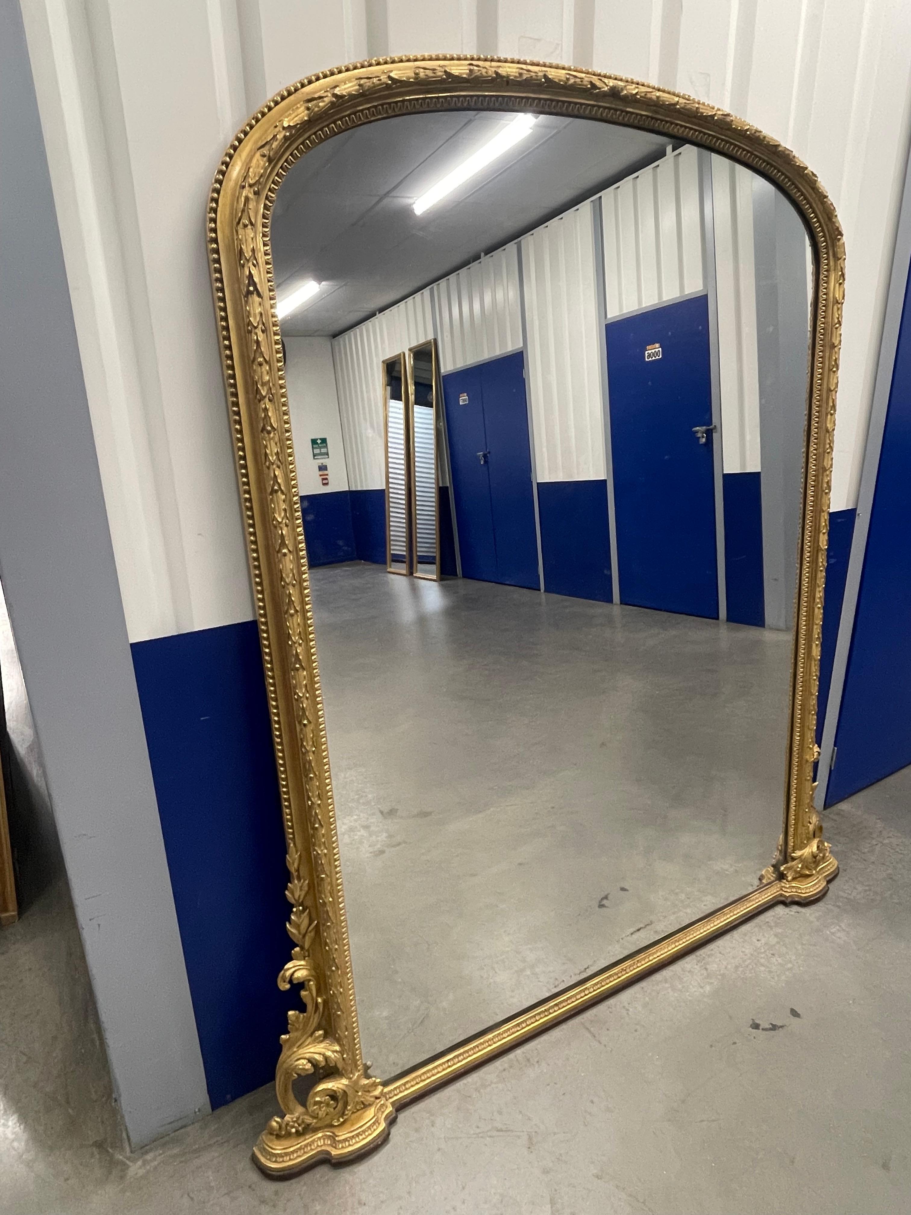 Miroir de cheminée du 19e siècle en vermeil, à décor de feuilles de laurier et de perles. Détails de feuillage à la base.

Les plaques de miroir originales, argentées à la main selon des méthodes traditionnelles, présentent souvent un caractère