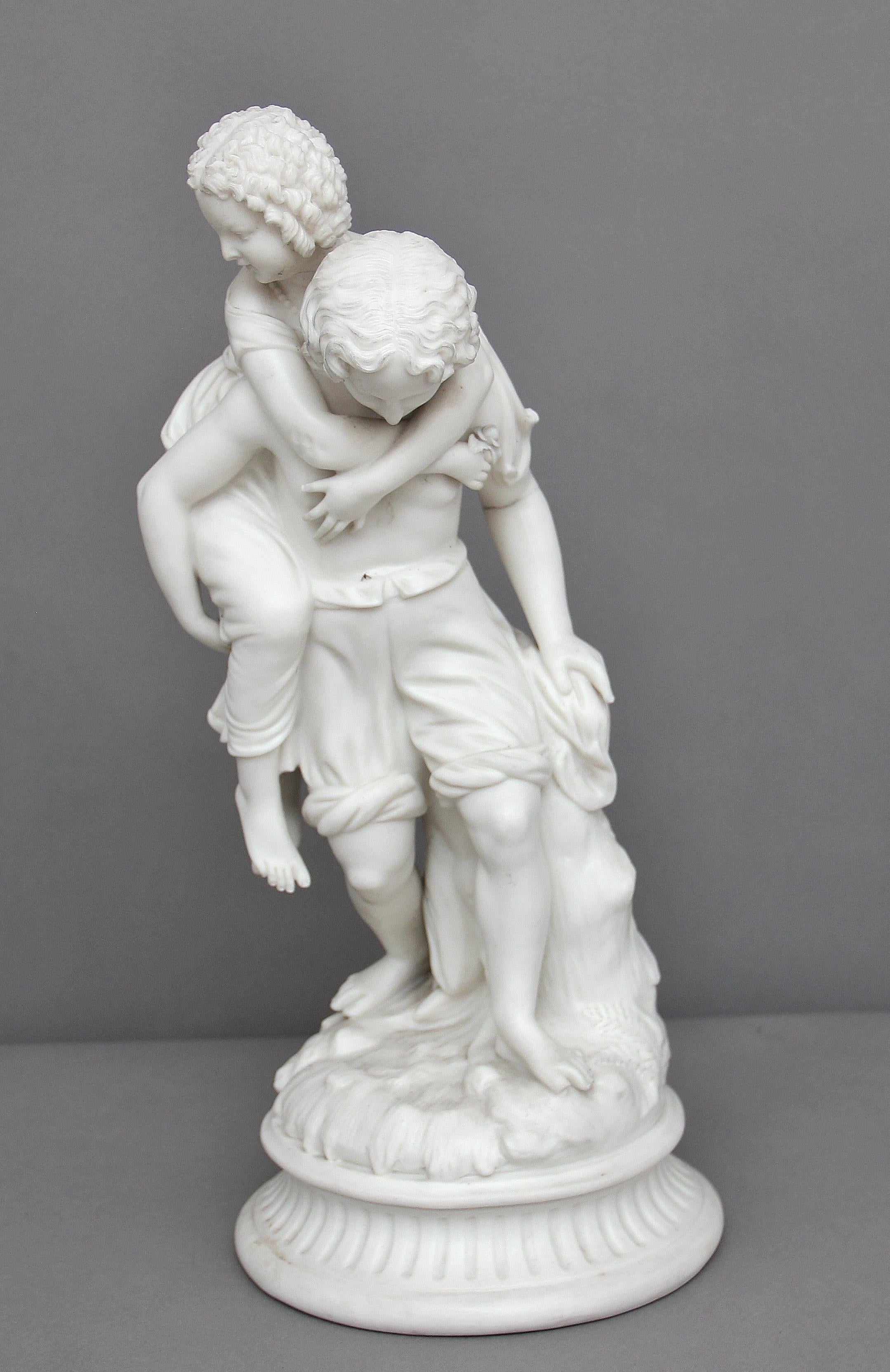 19th century parian figure of a boy with a girl upon his back, on a rocky outcrop. Slight damage on the boys toe, circa 1860.