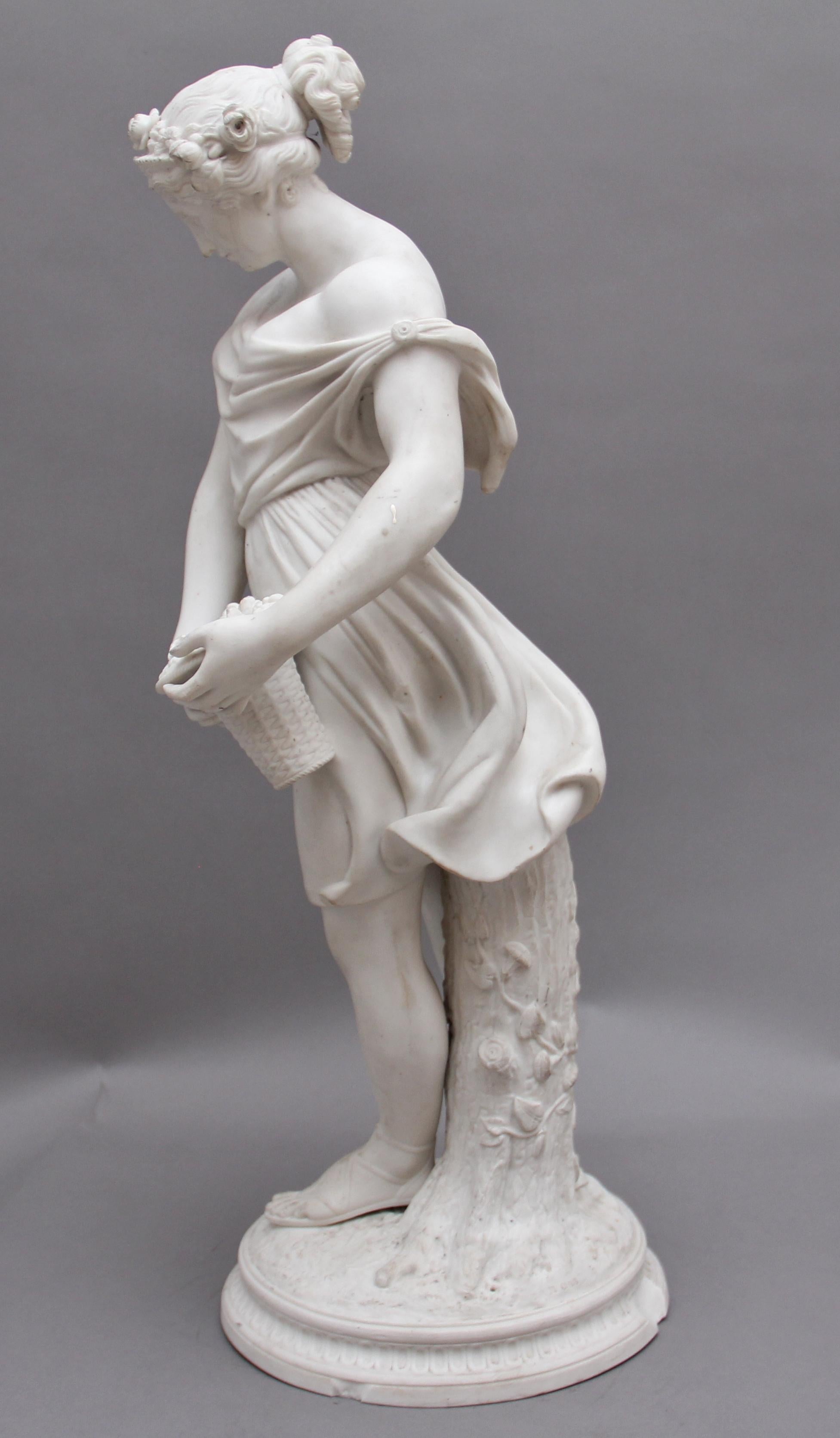 Figura pariana del XIX secolo raffigurante una fanciulla fiorita; la donna tiene in mano un cesto di fiori e si appoggia a un tronco floreale, con dettagli meravigliosi. La base presenta alcuni danni in alcuni punti. Circa 1850.
 