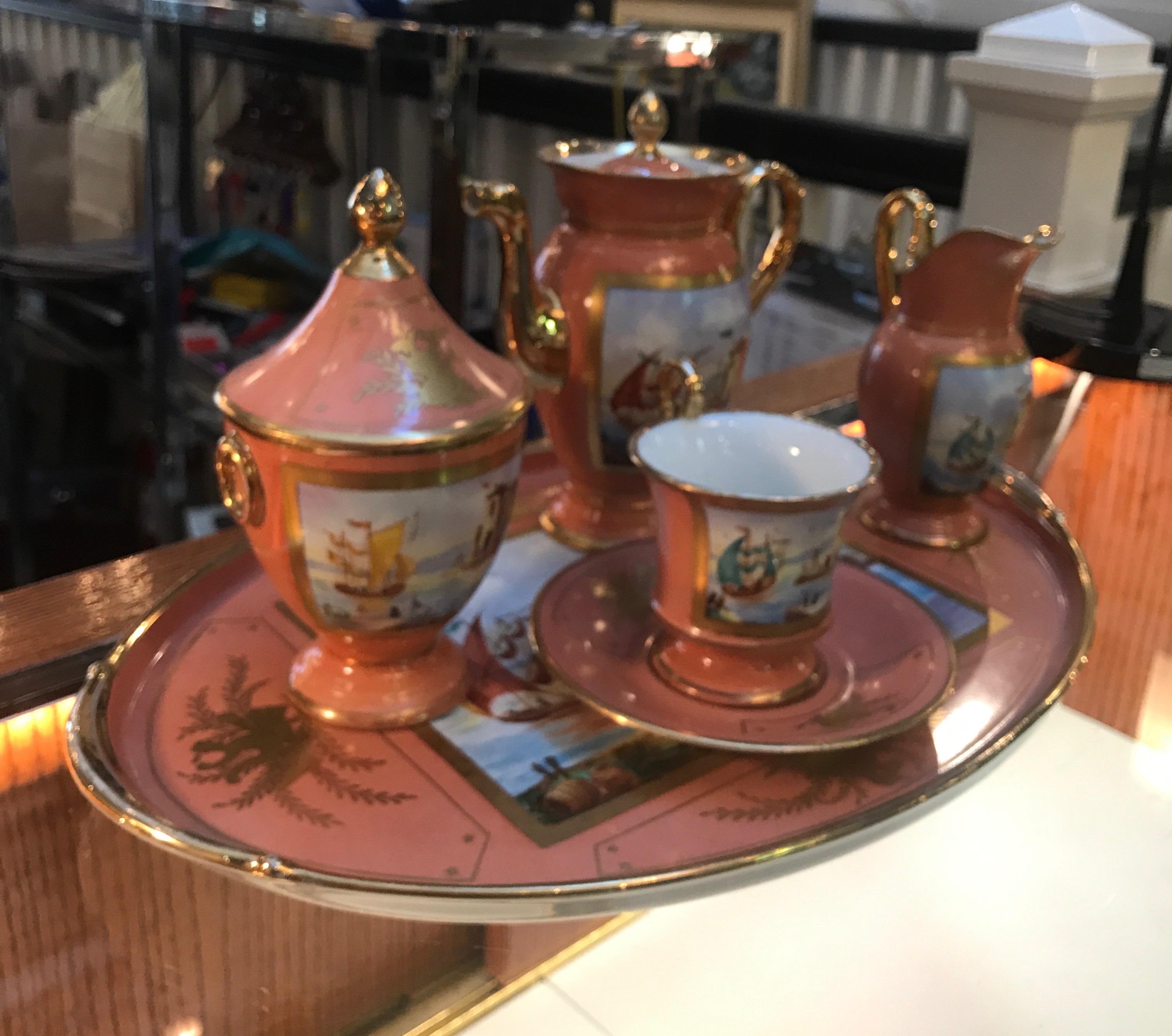 A beautifully hand painted porcelain tea set with an salmon color background. Each piece with a Venetian scene complete with tray. Tea pot, sugar bowl, creamer cup and saucer. The tray measures 16 inches by 10.5 inches.