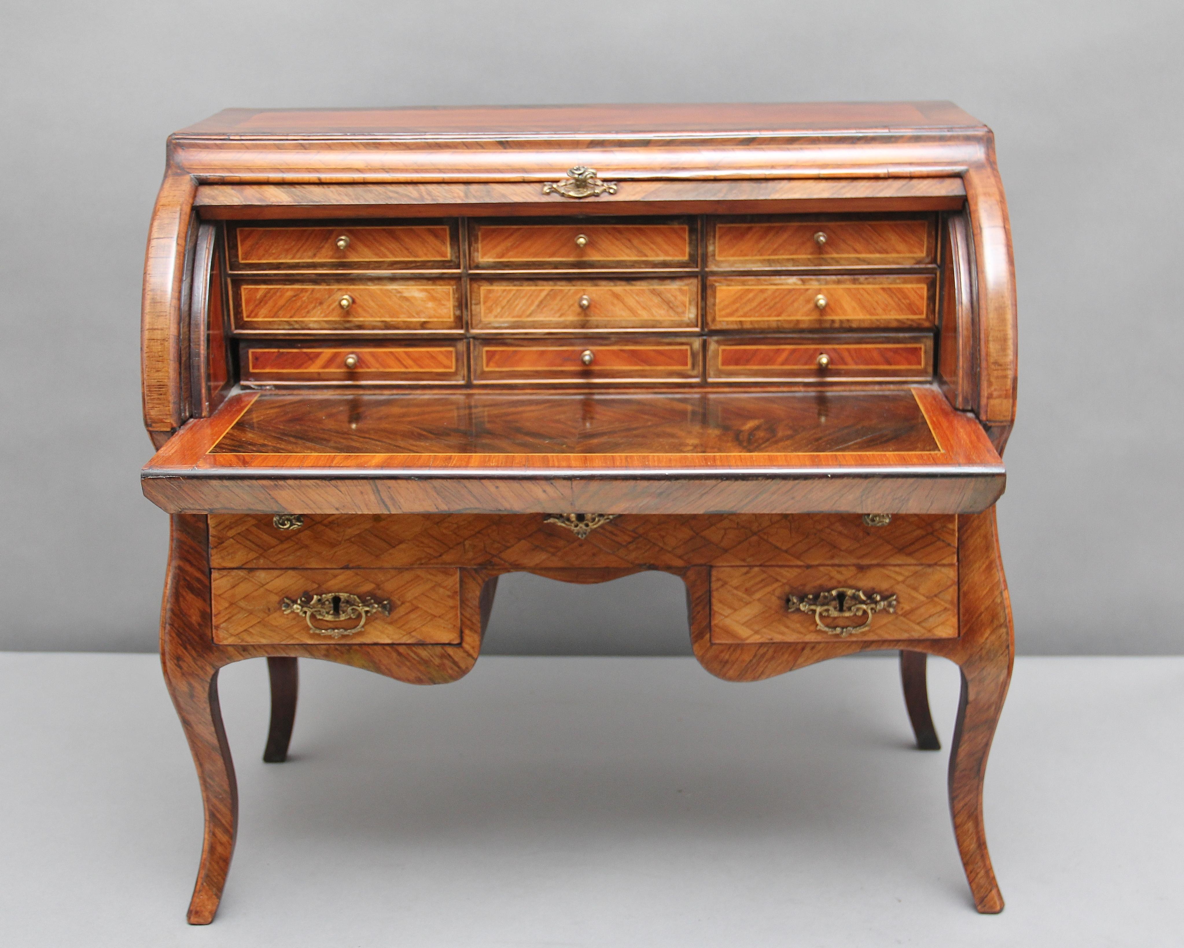 A superb quality early 19th century miniature bureau / desk made from Kingwood, tulipwood and other exotic woods, having a crossbanded top, parquetry inlaid bureau fall, drawer fronts and the sides of the desk, original brass handles and