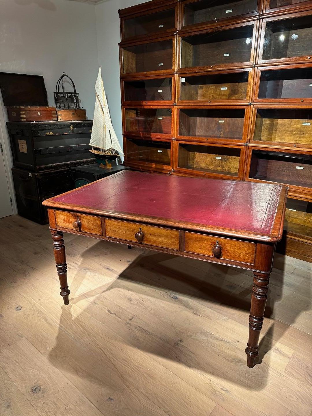 Antique mahogany writing table with 3 drawers on both sides. The table has a Bordeaux red leather top. Beautiful  patina and warm color of the mahogany. The table is in good and completely original condition.

Origin: England
Period: Approx.
