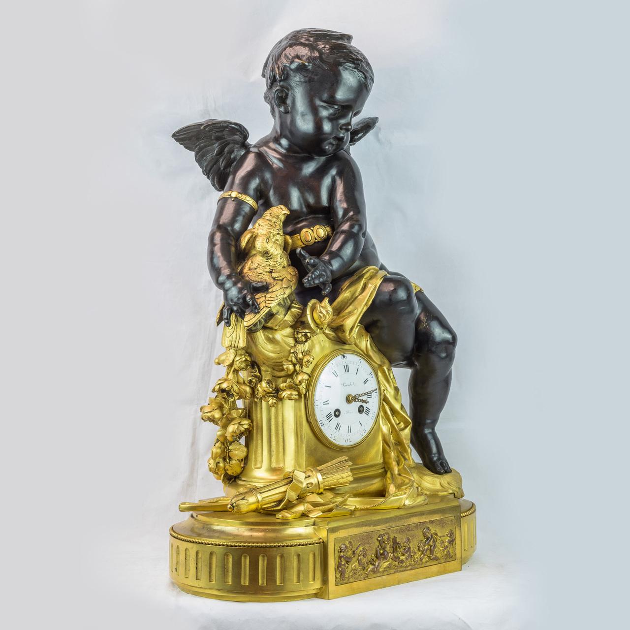 A Majestic patinated bronze putto seated on a gilt mantel clock.
Modelled with a seated putto holding two doves, the putto leaning over a gilt mantel clock with garland, surmounted by a bow and arrow raised on a plinth base. 
Date: circa
