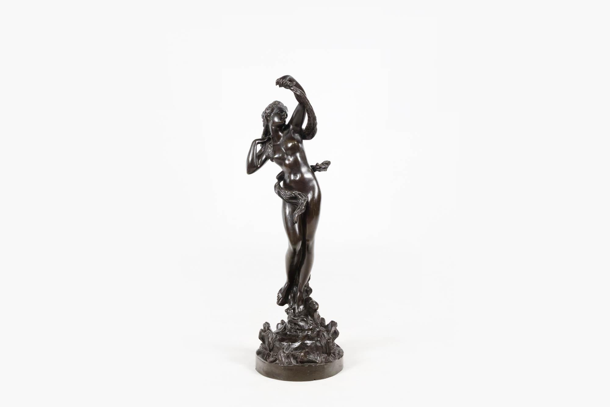 Sculpture en bronze patiné du XIXe siècle représentant une figure féminine dansante, peut-être une nymphe de la mer. La figure repose sur un socle de coquillages et de répouses faisant tournoyer un drapé autour de son corps. Il capture