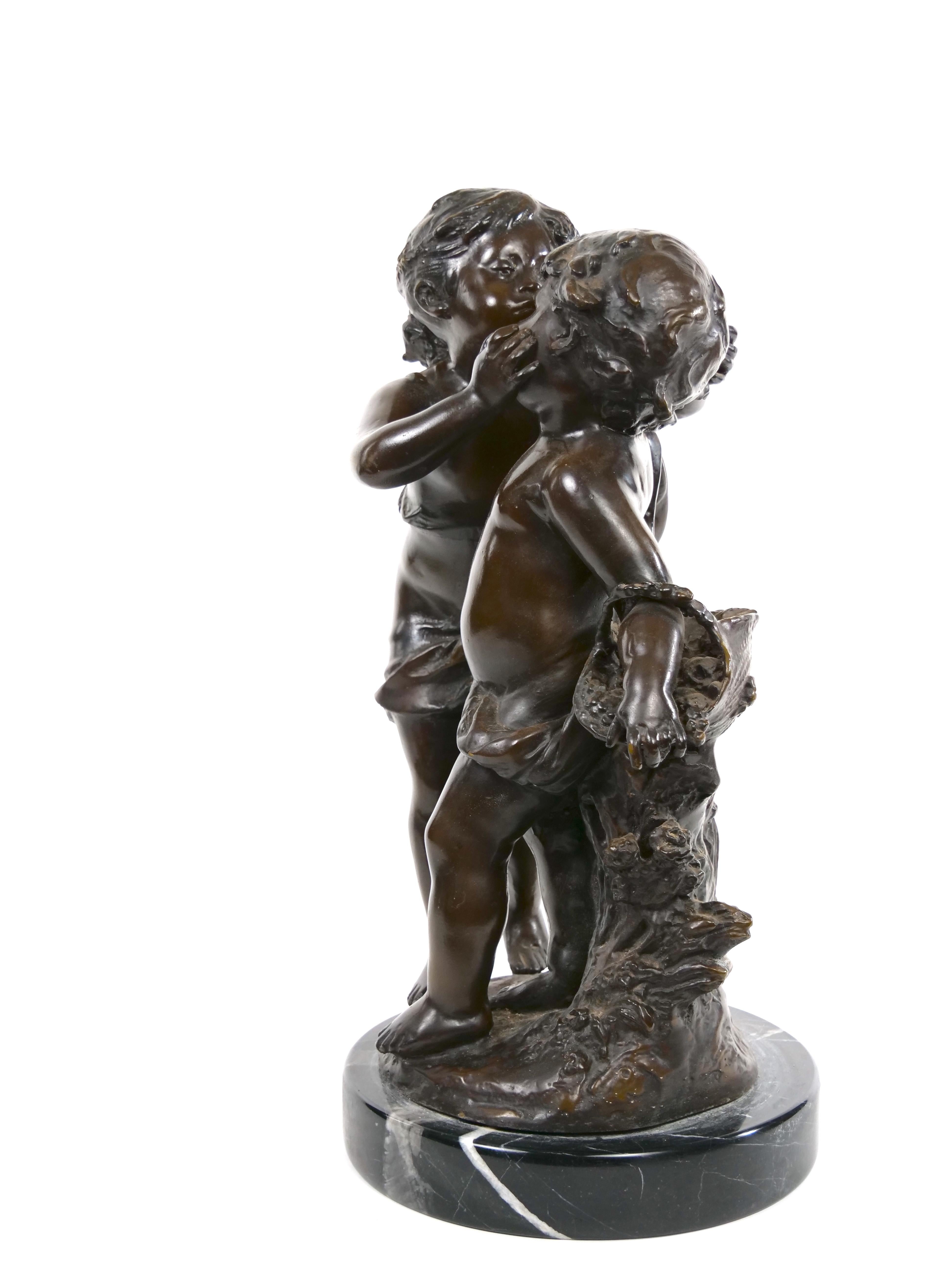 This large patinated bronze statue of a girl kissing a boy in the manner of Auguste Moreau (1834-1917) dates from the late nineteenth century. Apparently unsigned and mounted on round marble base. With dark brown patina and in good condition.