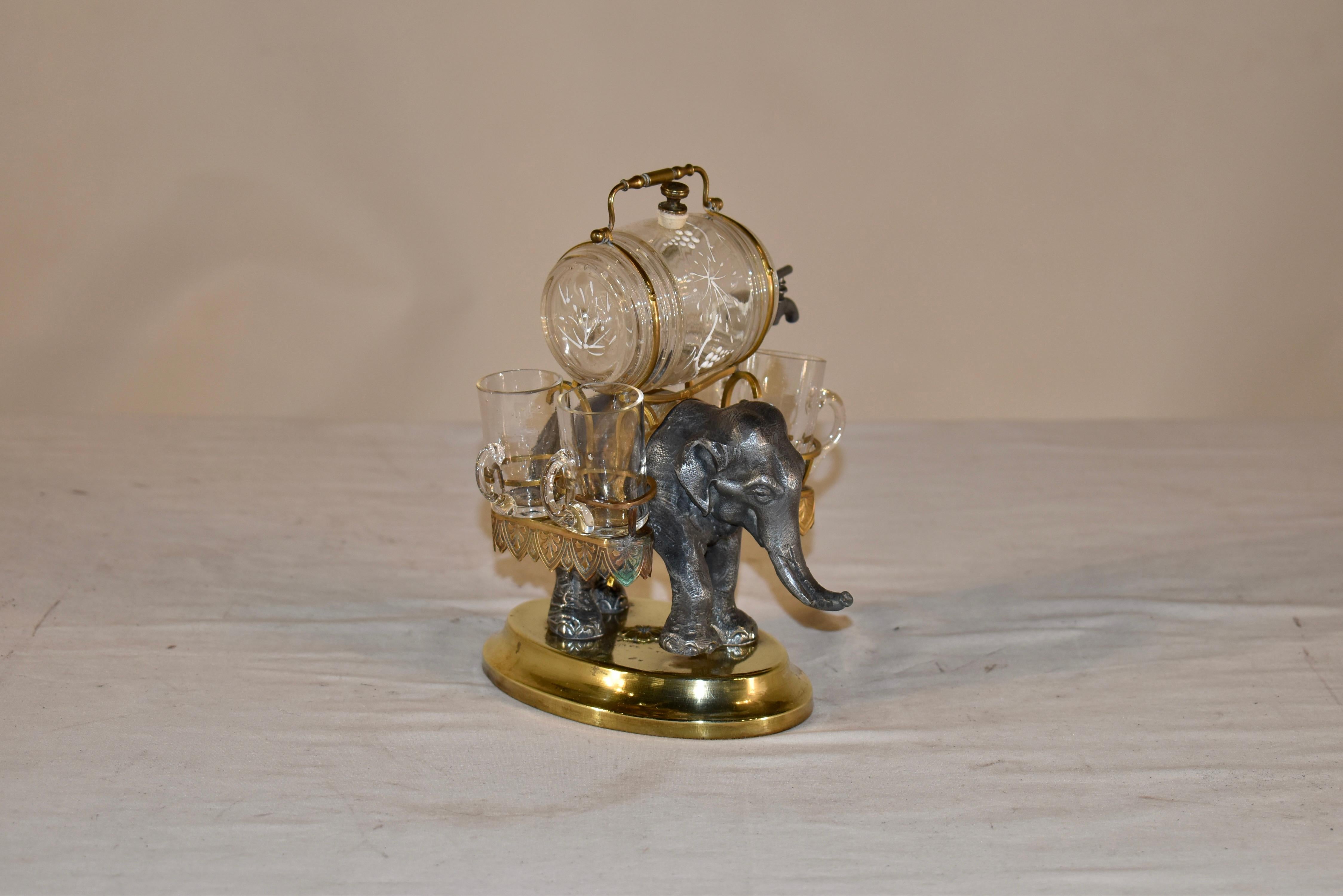 This is an extremely fine neoclassical French ornamental cast bronze, brass, and glass liqueur set, circa 1840.  This fabulous liqueur set is in the form of a finely patinated bronze sculpture of an elephant walking along and carrying a brass howdah