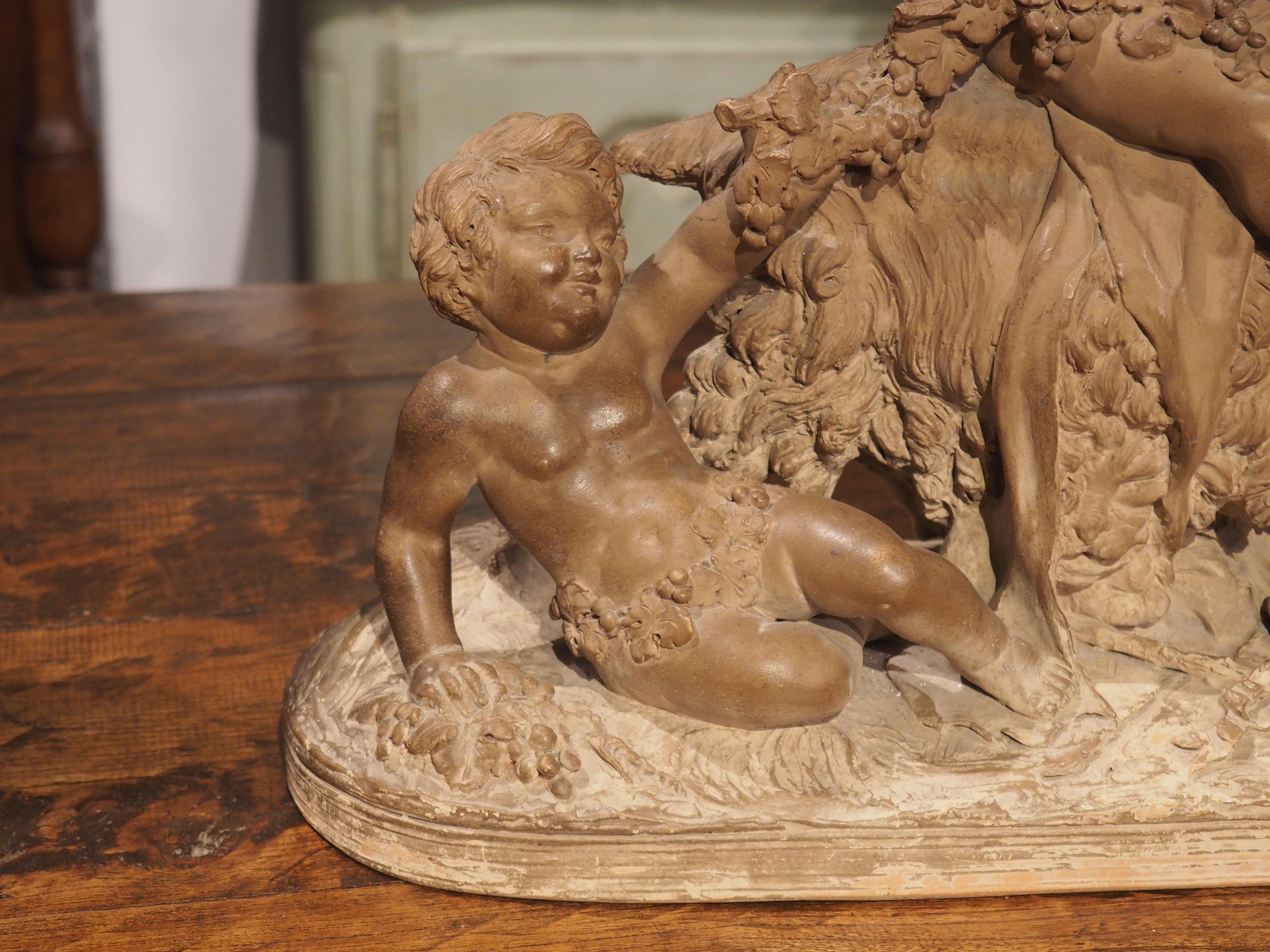 A lovely depiction of the neoclassical taste, three putti can be seen playing with a goat. The terra cotta sculpture from the 1800s has a variegated patination, with hues of dark ochre, gray, and cream.

Each putto is bedecked with a ring of