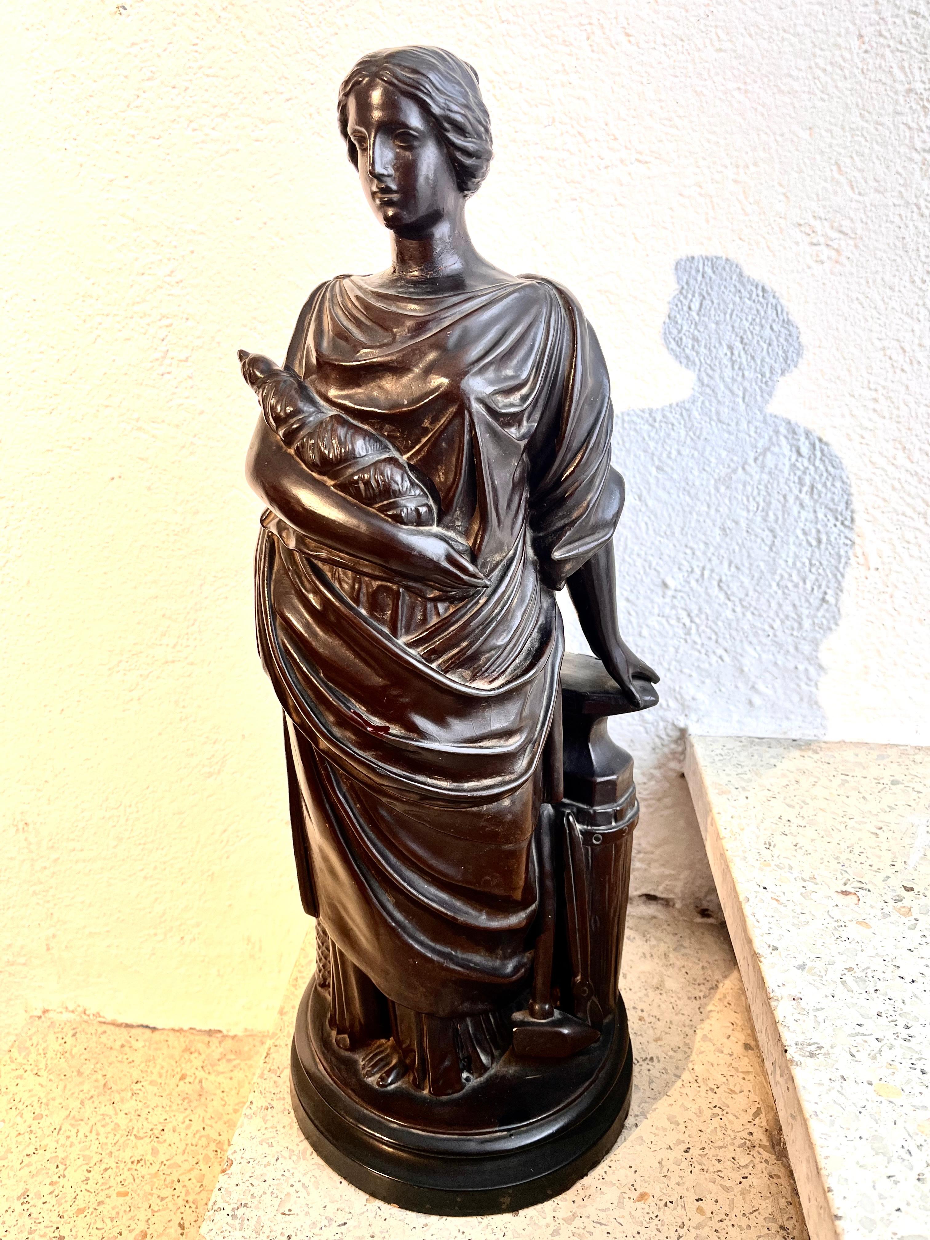 Scultura francese, figura femminile che rappresenta l'Allegoria del Lavoro, realizzata in terracotta patinata nera, firmata sulla base con la data di fabbricazione e le iniziali.