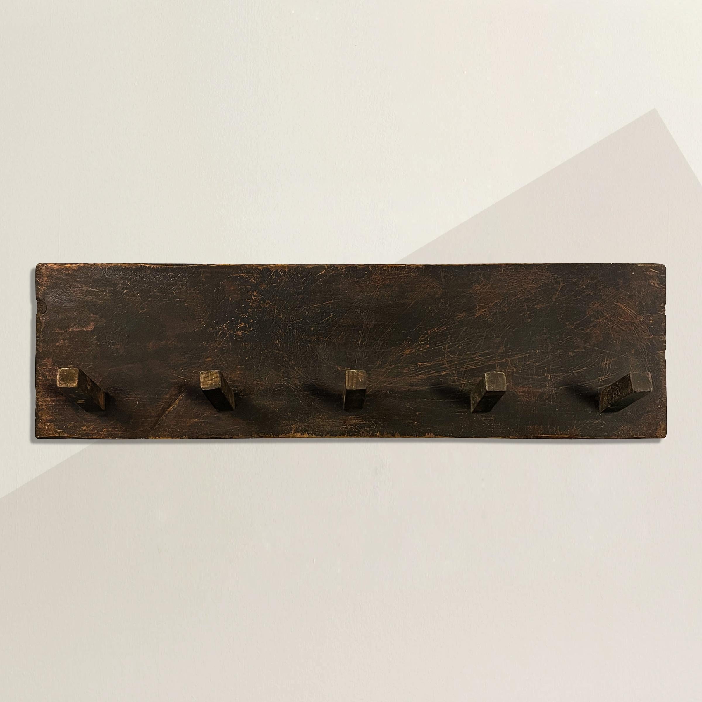 A charming late 19th century American painted wood pegboard from a farm, but today it's the perfect coat or hat rack, or broom and brush rack in your country cottage.