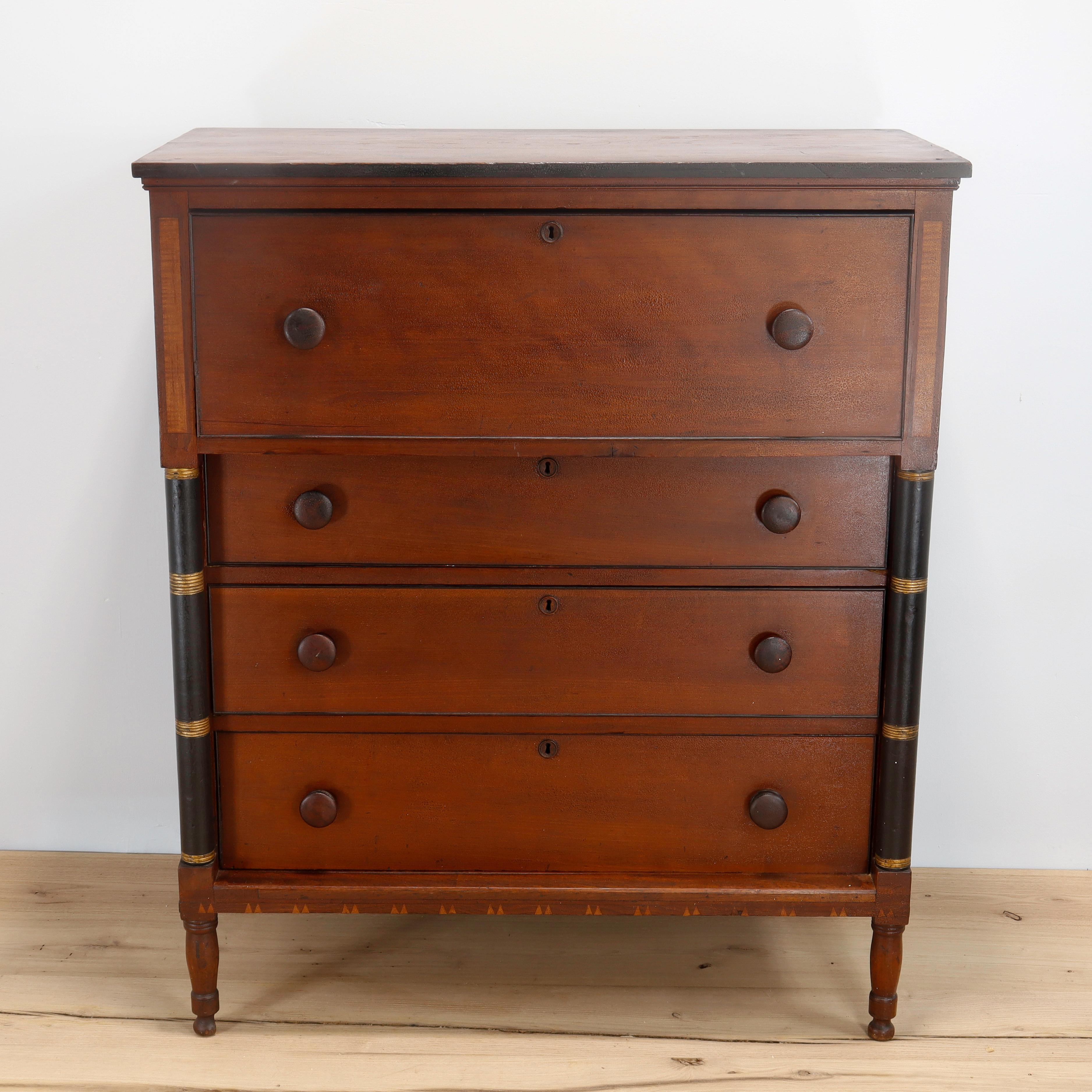 A fine antique wooden chest of drawers.

With a terrific old finish.

In cherry wood with a polar secondary, turned wooden pulls, and round wooden escutcheons. 

Painted with black highlights to edge and with black & gold paint to turned side
