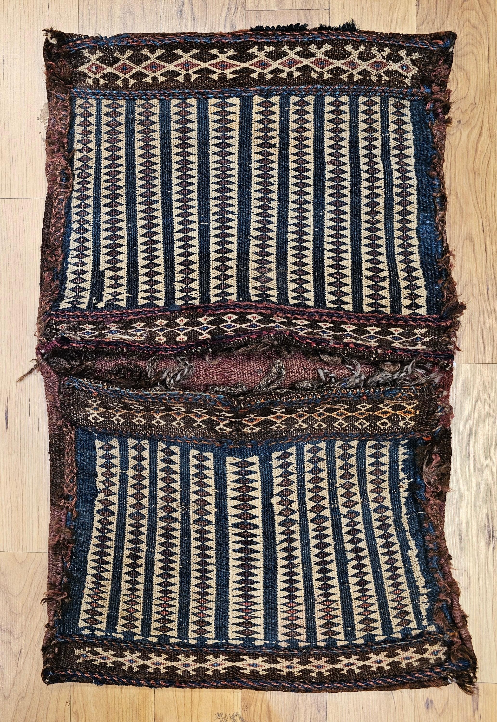 Sacoche double en soumak tribal baloutche persan du XIXe siècle.   Le devant du sac présente un magnifique motif géométrique de couleur vert/bleu sur fond jaune.  La variation de couleur dans le design vert/bleu est très belle.  Les sacoches doubles