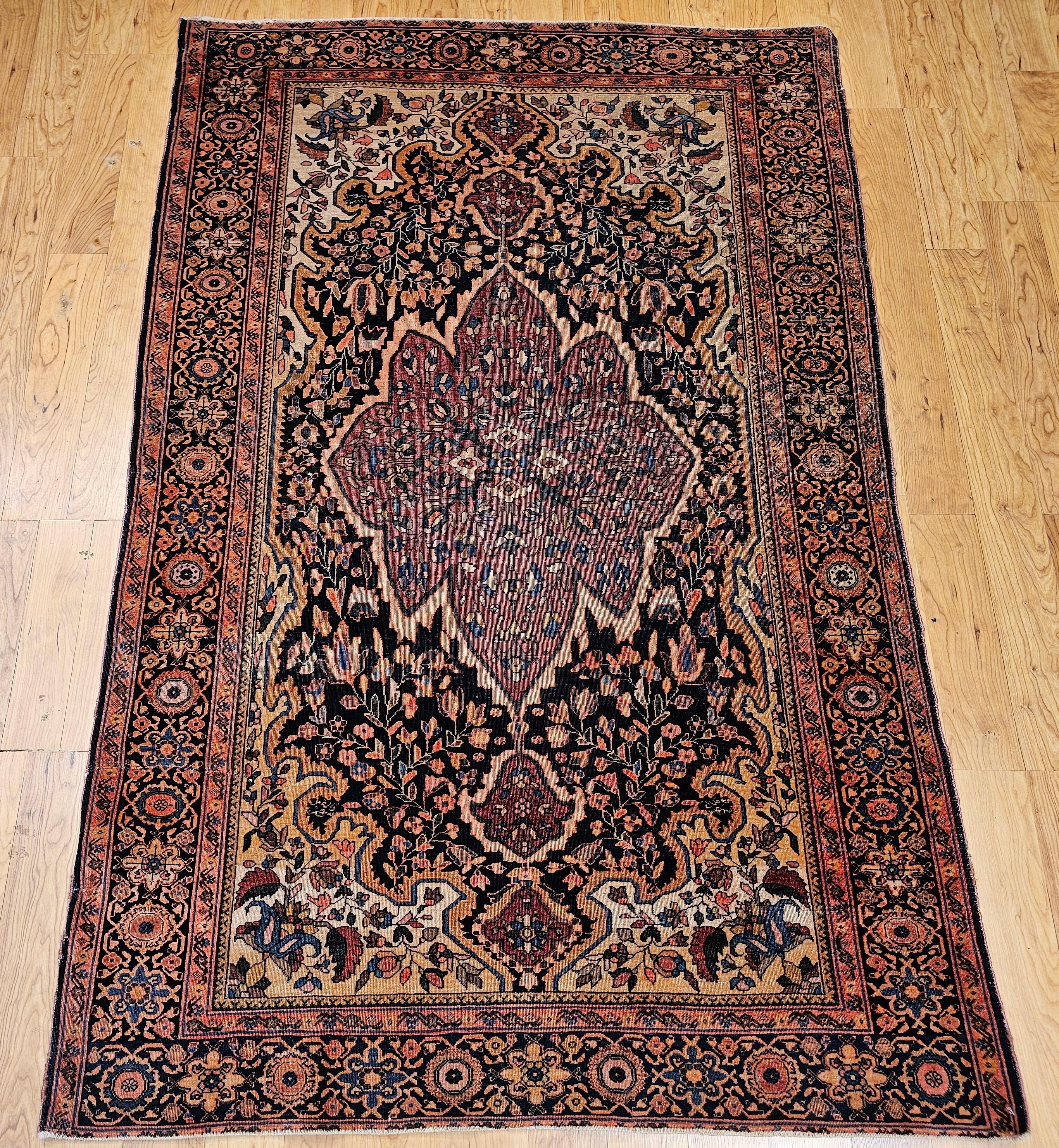 Persischer Farahan-Sarouk-Teppich aus dem späten 19. Jahrhundert mit Medaillonmuster und floralem Dekor in den Farben Marineblau, Pflaumenrot, Hellgelb und Französisch-Blau.  Das Feld hat ein florales Muster auf marineblauem Hintergrund.  Es gibt
