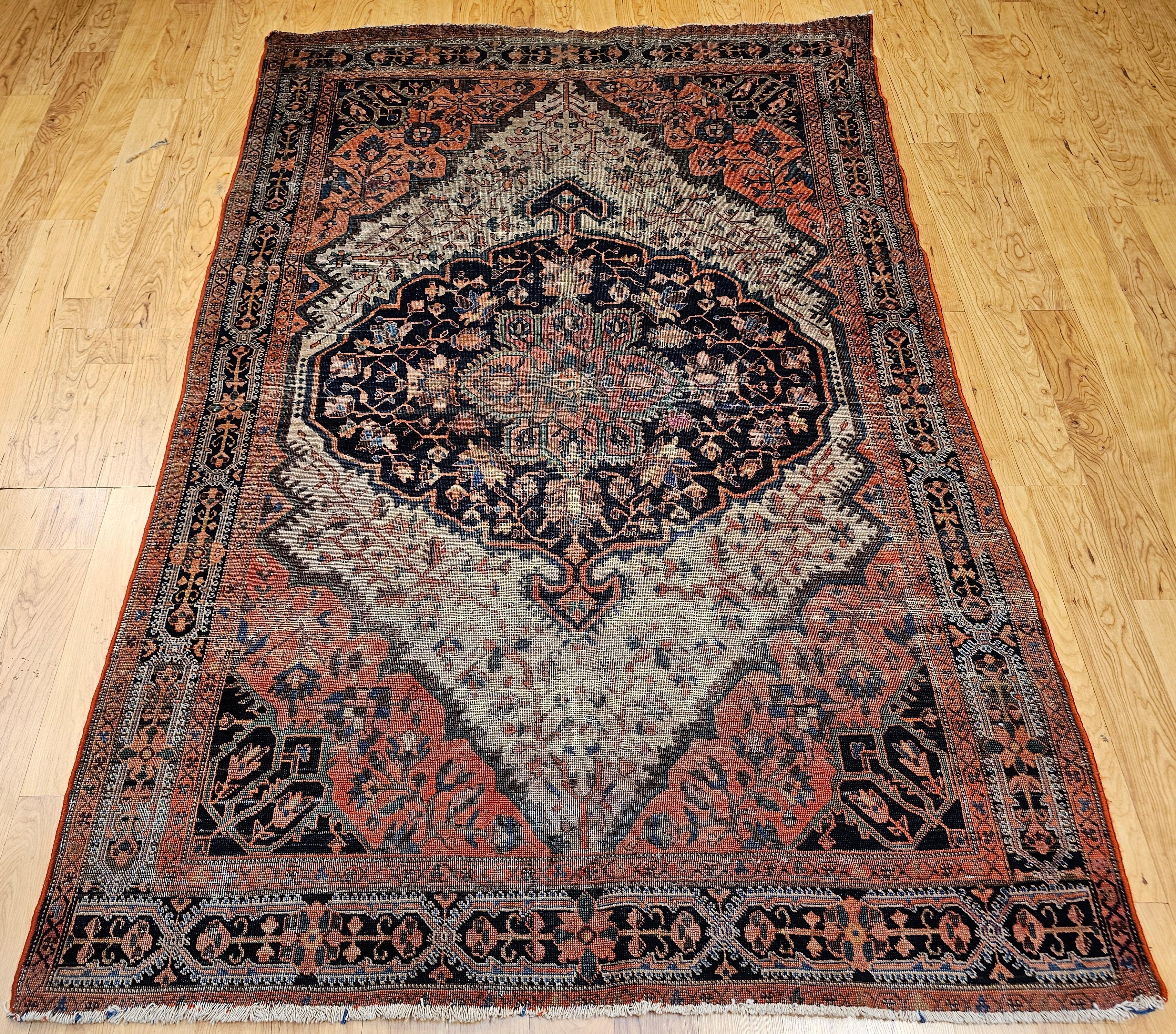 Bellissimo tappeto persiano Sarouk Farahan con motivo floreale a medaglione nei colori blu navy, rosso terracotta e cammello dei primi anni del 1900.  Il design complessivo del tappeto è molto grandioso e presenta un insolito disegno a medaglione. 