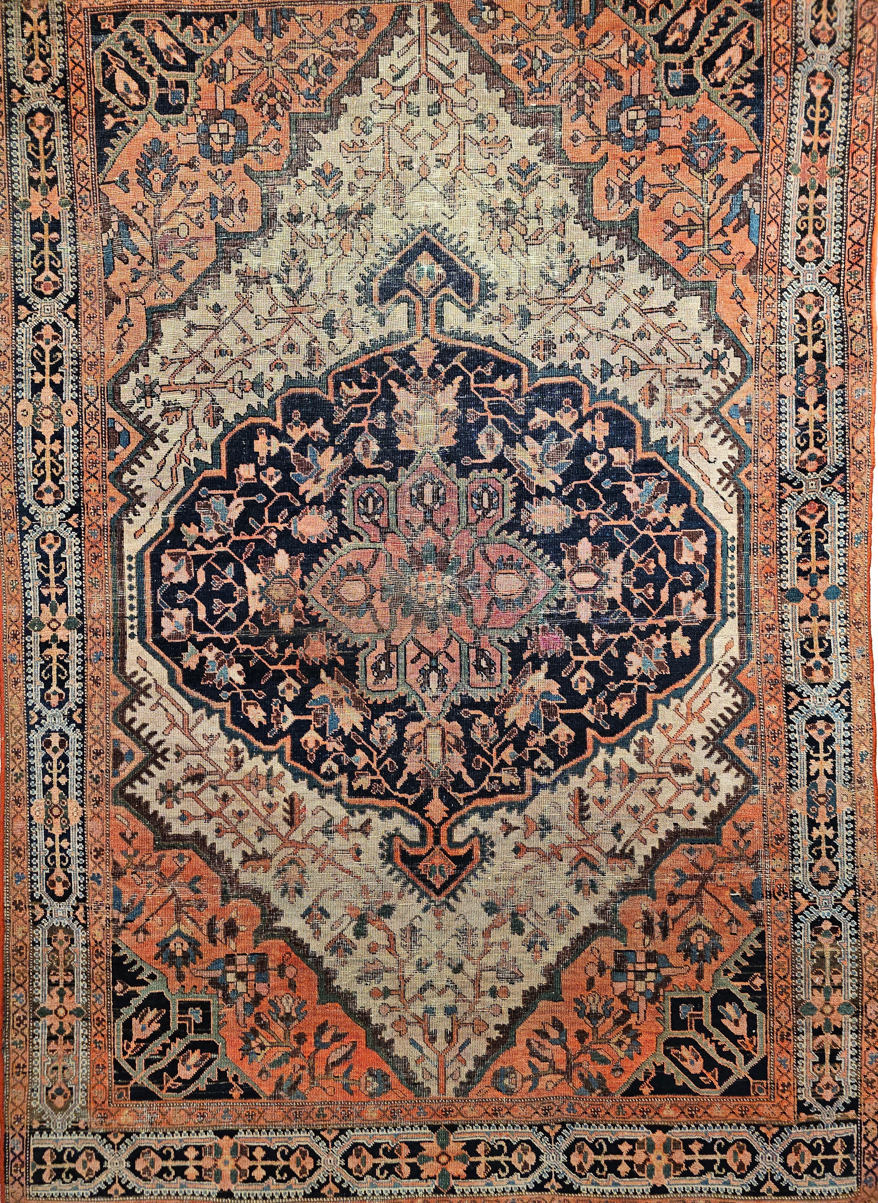 A beautiful Persian Farahan Sarouk area rug in a medallion floral pattern in navy blue, terracotta Red, and camel colors from the late 1800s.  The overall design of the rug is very grand with a very unusual medallion design.  The rug has a camel
