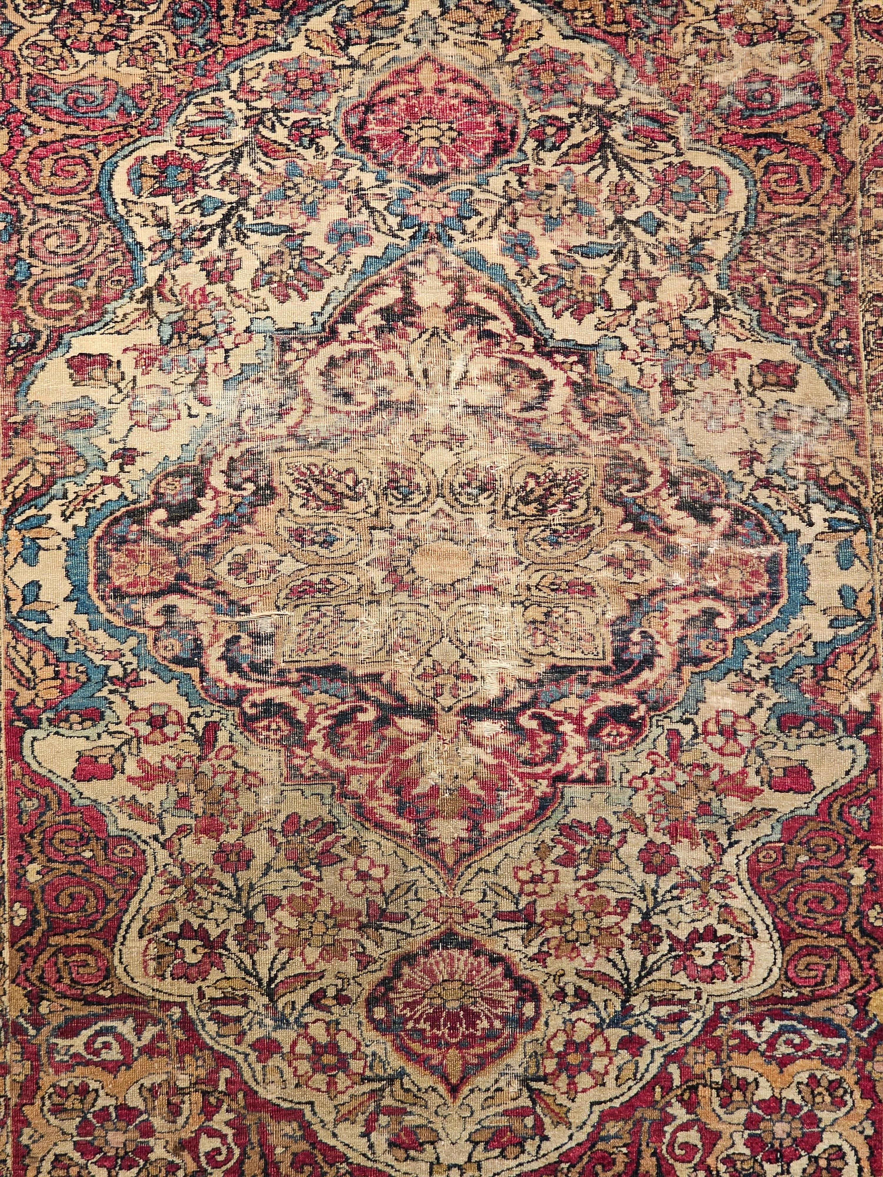 Mid 19th century Persian Kerman Lavar area rug in floral design with ivory, red, and French blue colors.  The rug has a gorgeous design and wonderful color combination.  The rug has a central medallion in navy blue and caramel with floral designs in