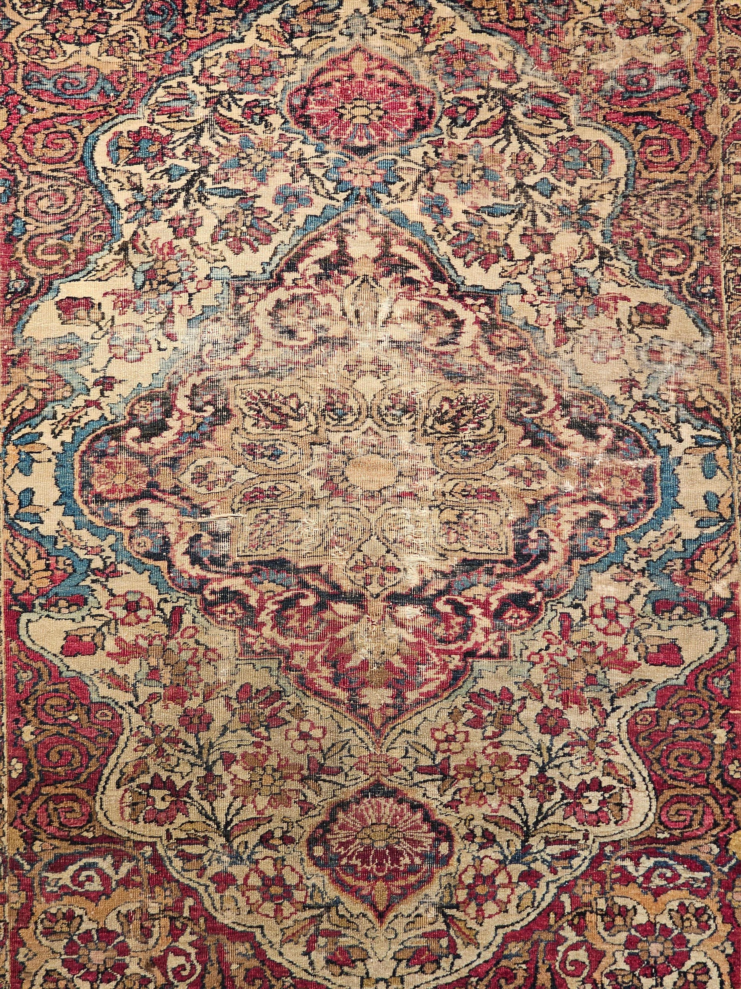 Tappeto persiano Kerman Lavar del XIX secolo con disegno floreale nei colori avorio, rosso e blu francese.  Il tappeto ha un design splendido e una meravigliosa combinazione di colori.  Il tappeto presenta un medaglione centrale in blu marino e