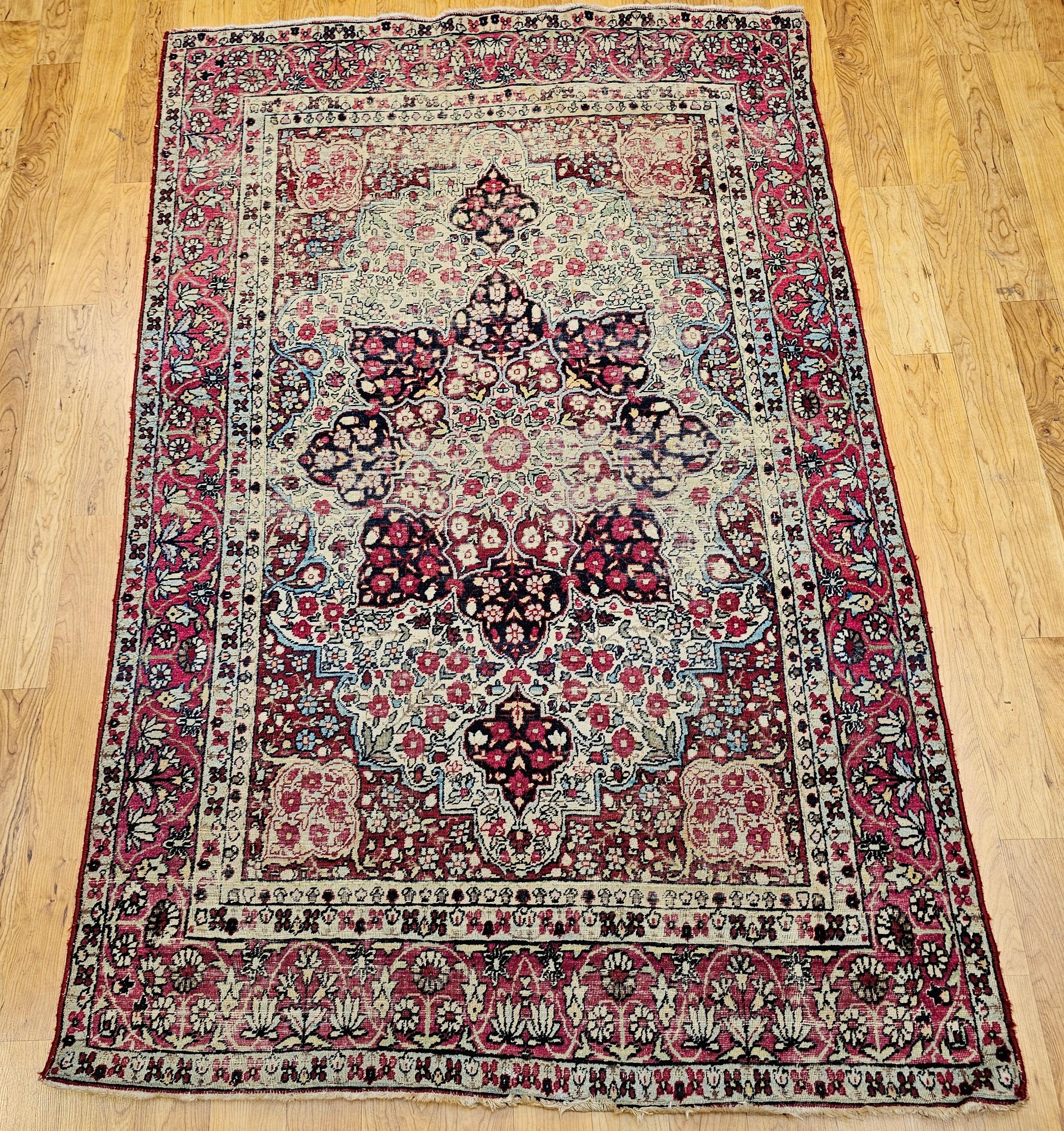 Ein schöner Lavar-Teppich aus Kerman aus den späten 1800er Jahren. Das Hauptfeld ist elfenbeinfarben, die Eckzwickel sind rot und die Umrandung ist rosarot. Der Teppich hat ein florales Muster in Rot, Hellblau und Cremefarben. Die Umrandung ist in